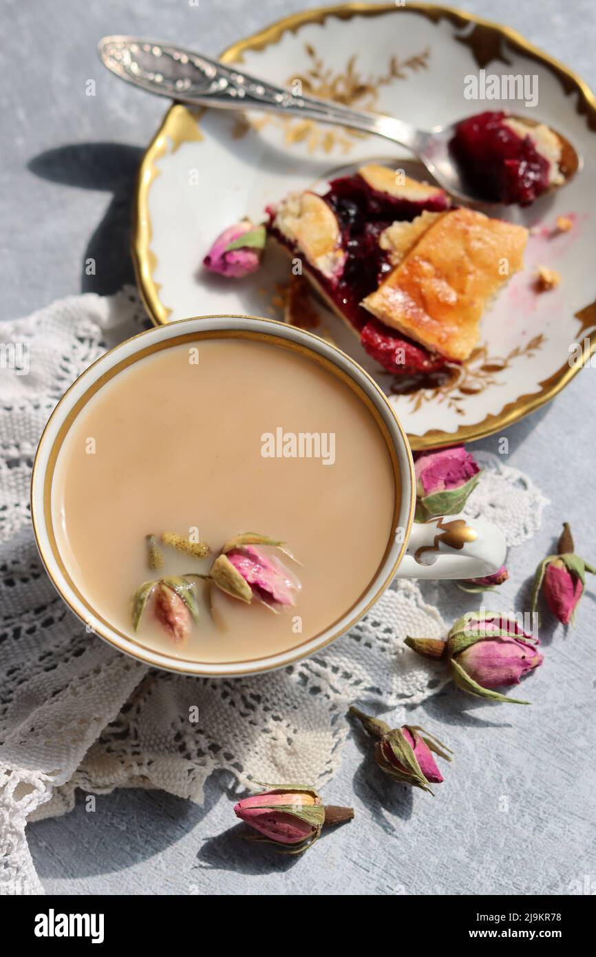 Tee mit Rosen Nahaufnahme Foto. Kräutertee in einer kleinen weißen Keramikschale auf einem Tisch. Hellgrauer Hintergrund mit Kopierbereich. Stockfoto