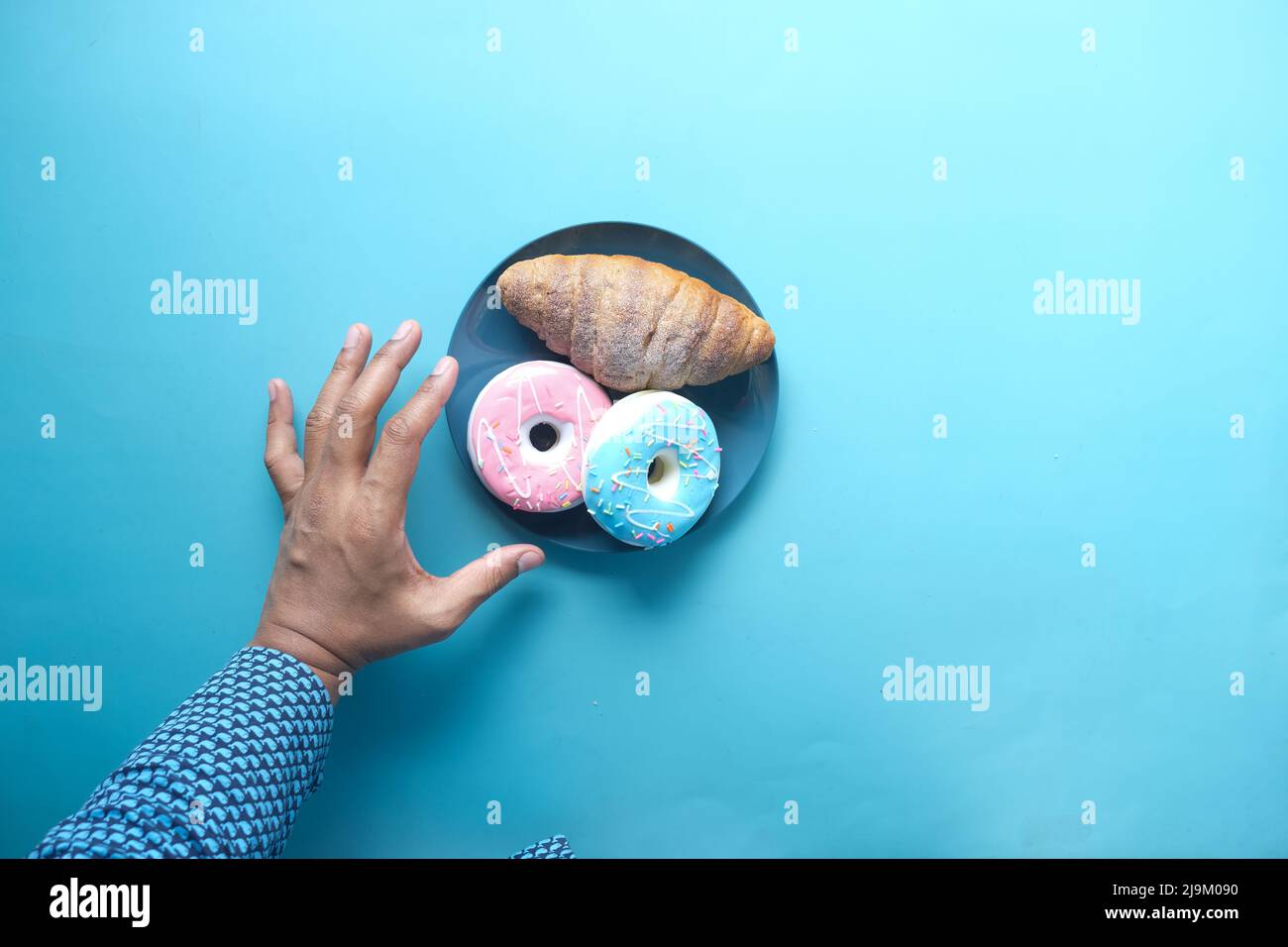 Hand hält frische Donuts Draufsicht Stockfoto