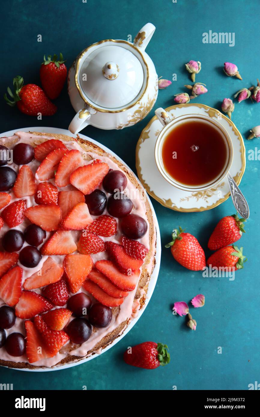 Erdbeerkuchen und Tasse schwarzen Tee auf einem Tisch. Stockfoto