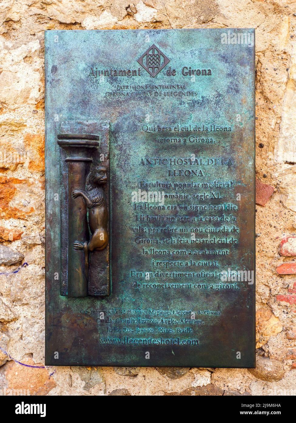 Eine Tafel an einer Wand, die die Tradition des Küssens der Steinstatue „La Lleona“ erklärt - Girona, Spanien Stockfoto