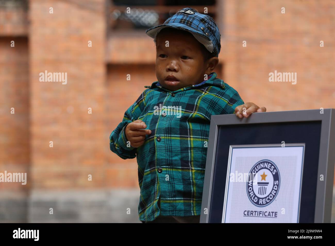 Am 24. Mai 2022 in Kathmandu, Nepal. Der Guinness-Weltrekordhalter der kürzesten lebenden Männer des Teenagers Dor Bahadur Khapangi hält das Guinness-Weltrekordzertifikat, während er bei der Vorbereitung des nepalesischen Tourismusbüros für das Foto posiert. Er misst die Khapangi-Höhe und beträgt 73,43 cm (2ft 4,9 Zoll) (Foto: Abhishek Maharjan/Sipa USA) Stockfoto