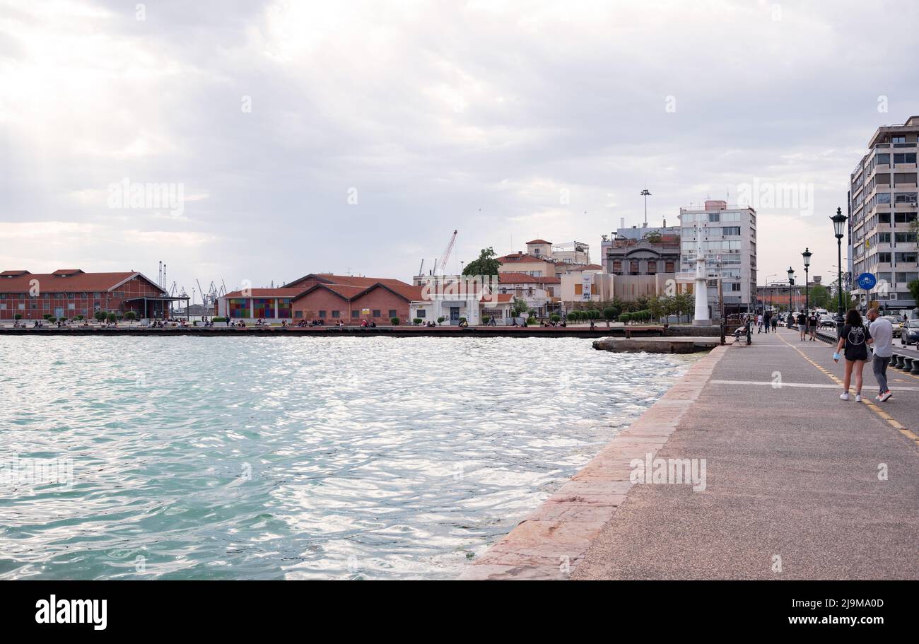 Wunderschöne Aussicht auf den Strandspaziergang, der an einem bewölkten Tag voller geschäftigen Touristen in der Nähe des Weißen Turms, einer berühmten Touristenattraktion in Thessaloniki, gefangen genommen wurde Stockfoto