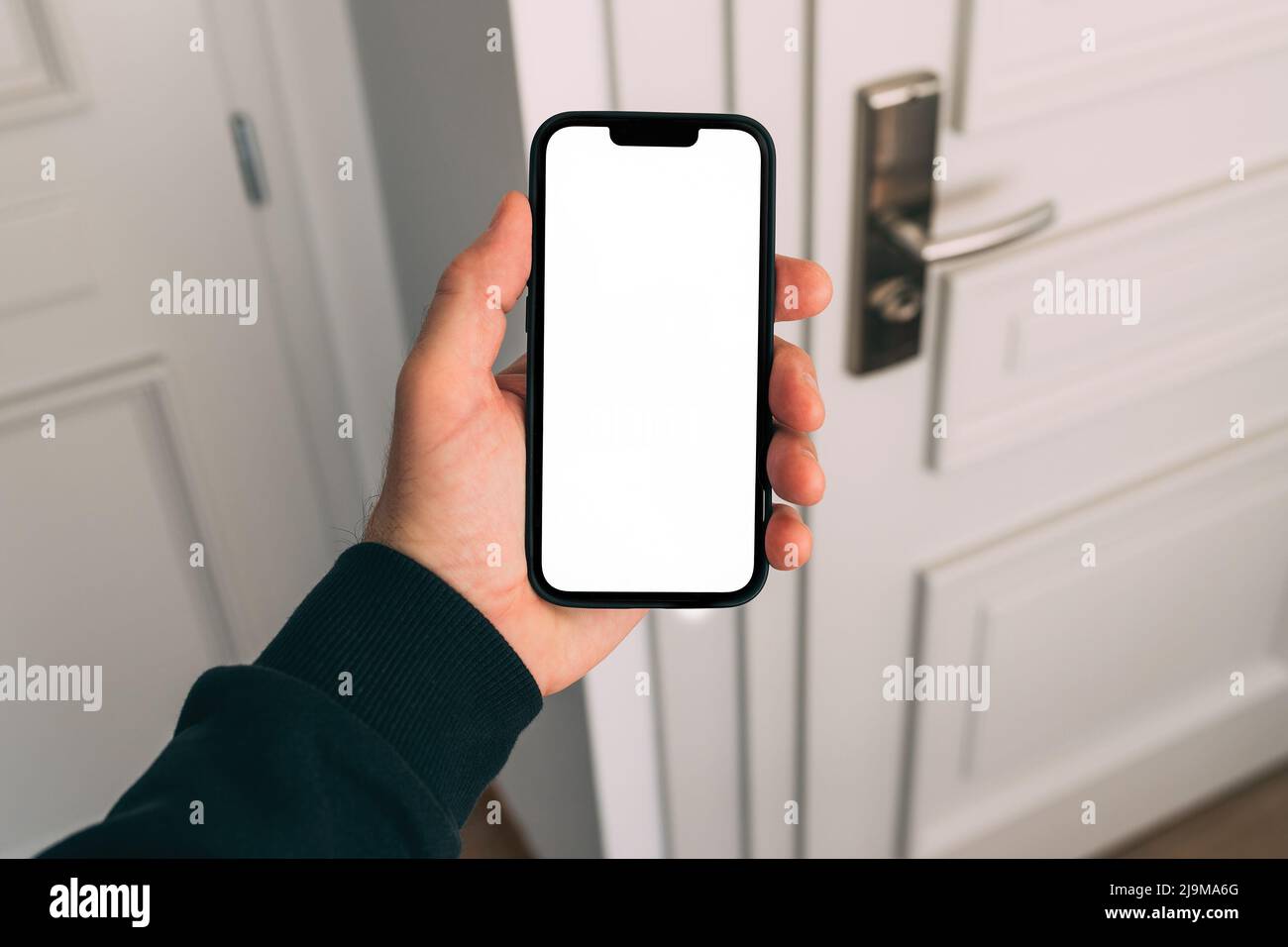 Smartphone-Mockup, Internet der Dinge und Smart-Home-Konzept, Mann mit Mobiltelefon. Nahaufnahme der Handhaltevorrichtung mit leerem Bildschirm im Home Interi Stockfoto