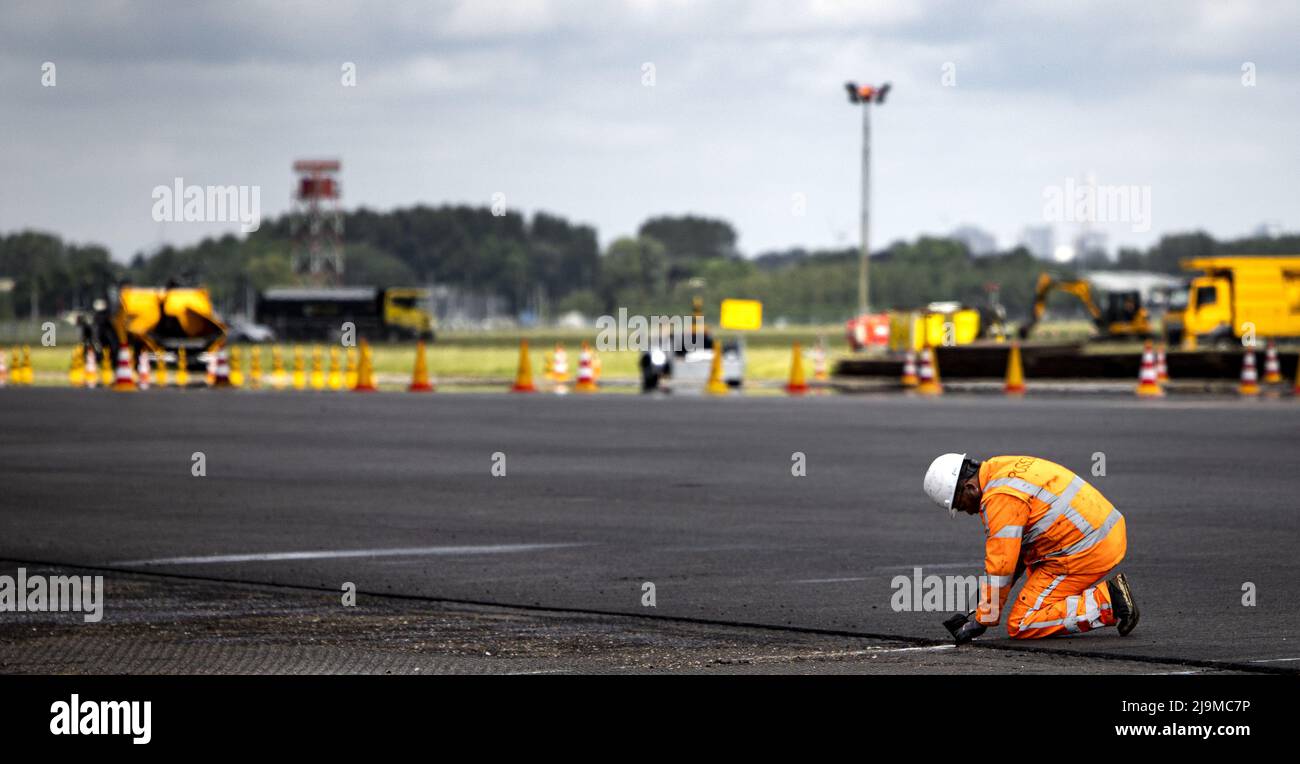2022-05-24 13:35:08 SCHIPHOL - Angestellte führen große Wartung auf dem Aalsmeerbaan durch. Während der Wartungsarbeiten wird der größte Teil der Strecke, eine Fläche von fünfzig Fußballfeldern, mit neuem Asphalt befahren. Außerdem werden 1650 neue LED-Lampen im Asphalt installiert, 50 Kilometer Kabel verlegt und 17 Kilometer Markierungen angebracht. ANP RAMON VAN FLYMEN niederlande Out - belgien Out Stockfoto 2022-05-24 13:35:08 SCHIPHOL - Angestellte führen große Wartung auf dem Aalsmeerbaan durch. Während der Wartungsarbeiten wird der größte Teil der Strecke, eine Fläche von fünfzig Fußballfeldern, mit neuem Asphalt befahren. Außerdem werden 1650 neue LED-Lampen im Asphalt installiert, 50 Kilometer Kabel verlegt und 17 Kilometer Markierungen angebracht. ANP RAMON VAN FLYMEN niederlande Out - belgien Out Stockfoto