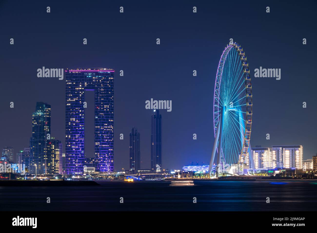 Farbenfroher Blick auf das beleuchtete Address Beach Resort und das Dubai Eye Ferris Wheel, das von der Palme Jumeirah West in Dubai, VAE, erfasst wurde. Stockfoto