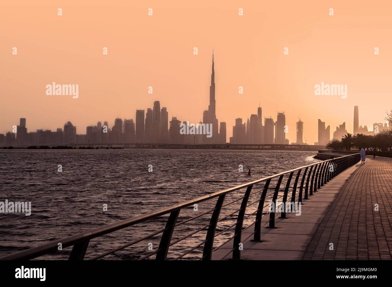 Panoramablick auf die Skyline von Dubai mit Burj Khalifa und anderen Wolkenkratzern, die bei Sonnenuntergang eine Silhouette bilden, von der Al Jadaf Waterfront aus, Stockfoto