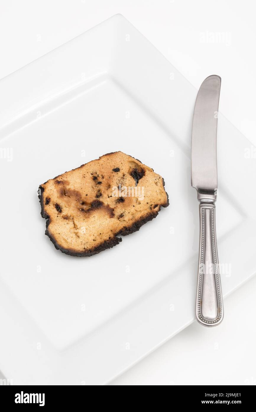 Brot, das auf einer Seite verkocht und zu einer Zünette verbrannt wurde. Bei Acrylamid und Krebs, Lebensmittel ungenügend zum Essen, schlechte Küchenkenntnisse, nicht in der Lage zu kochen. Stockfoto