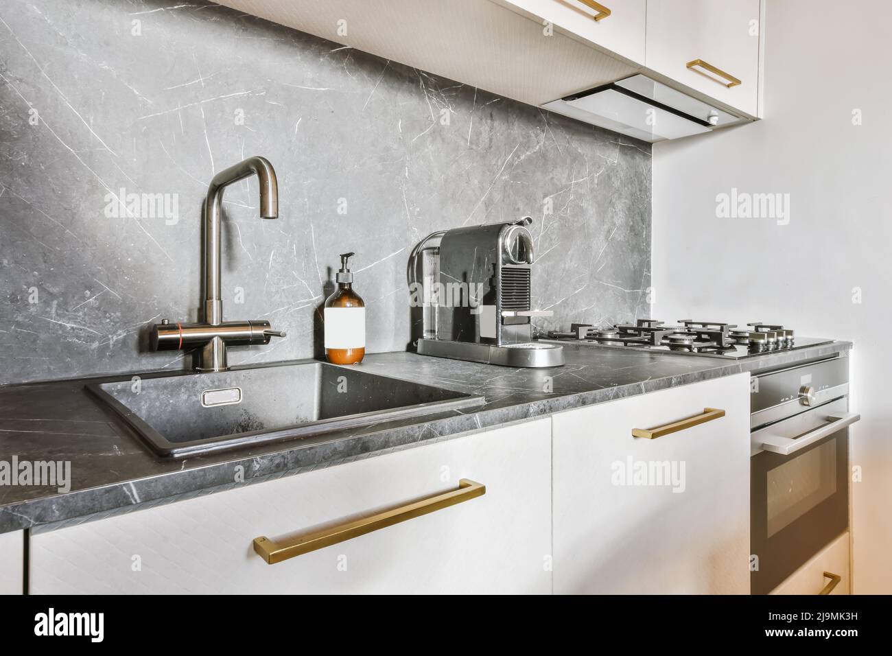 Moderne Küchenablagen, die sich tagsüber in einem hellen, offenen Raum zu Hause befinden Stockfoto