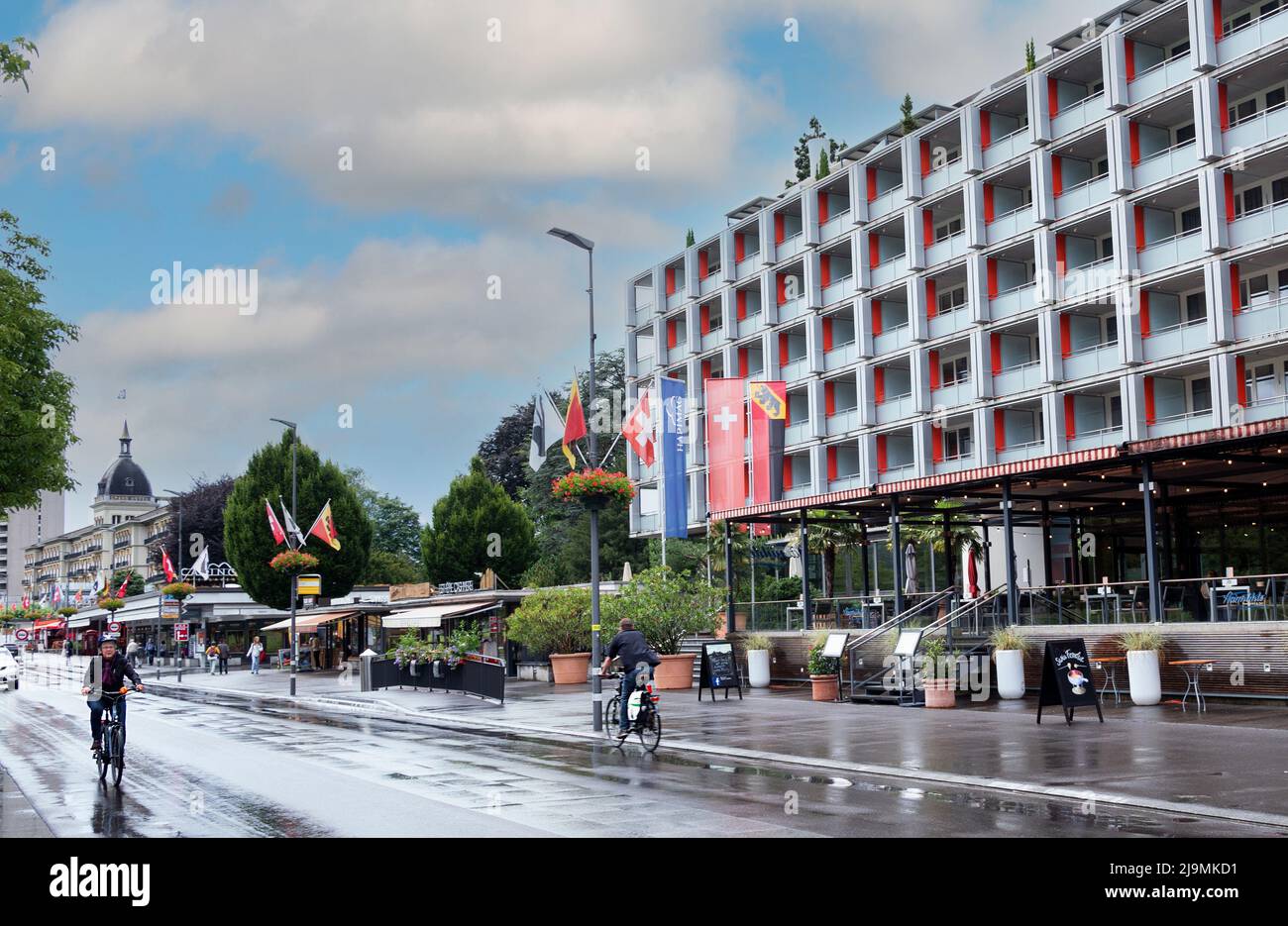 Die Hapimag Ferienwohnungen an der belebten Hauptstraße von Interlaken zusammen mit anderen Restaurants und Geschäften im Sommer. Stockfoto