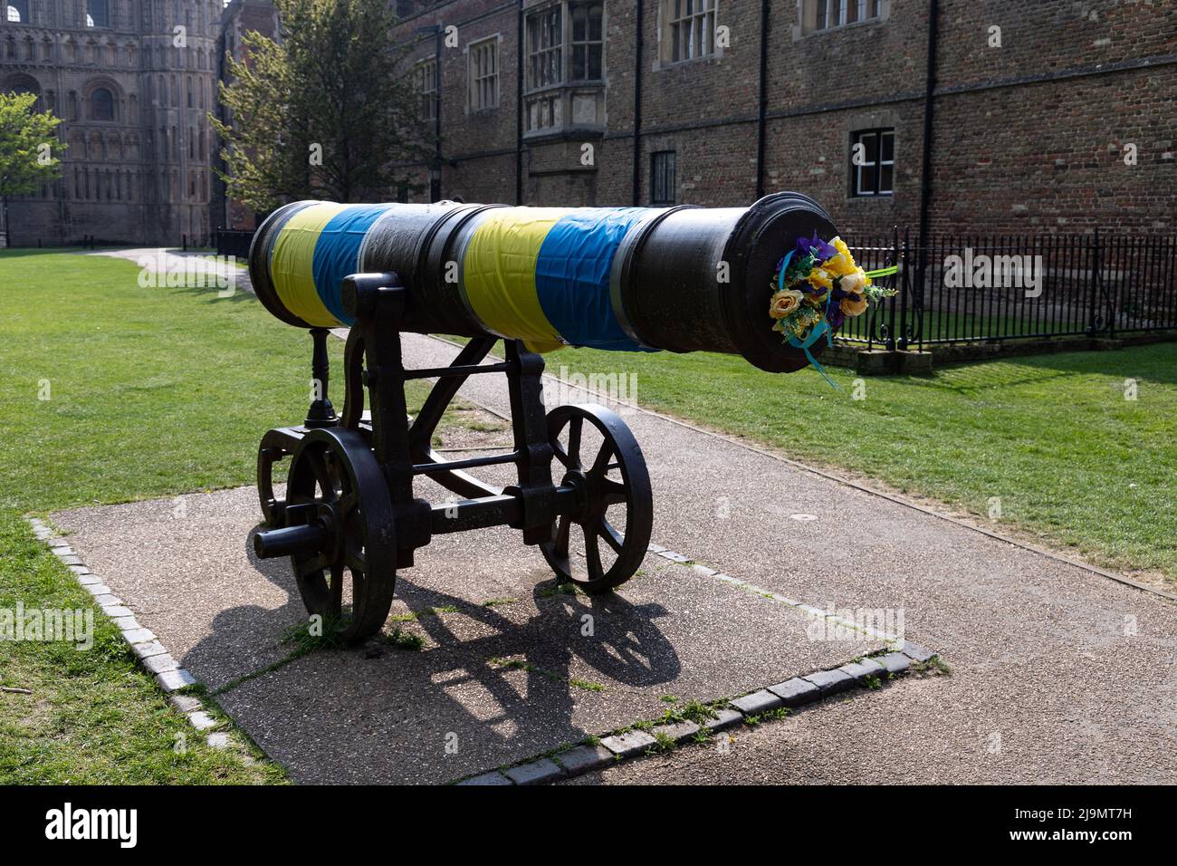 Gelbe und blaue Farben drapierten auf die Kanone, die vor der Ely-Kathedrale in der Ukraine steht, nachdem sie 2022 von Russland eingedrungen war. Aufgenommen Stockfoto
