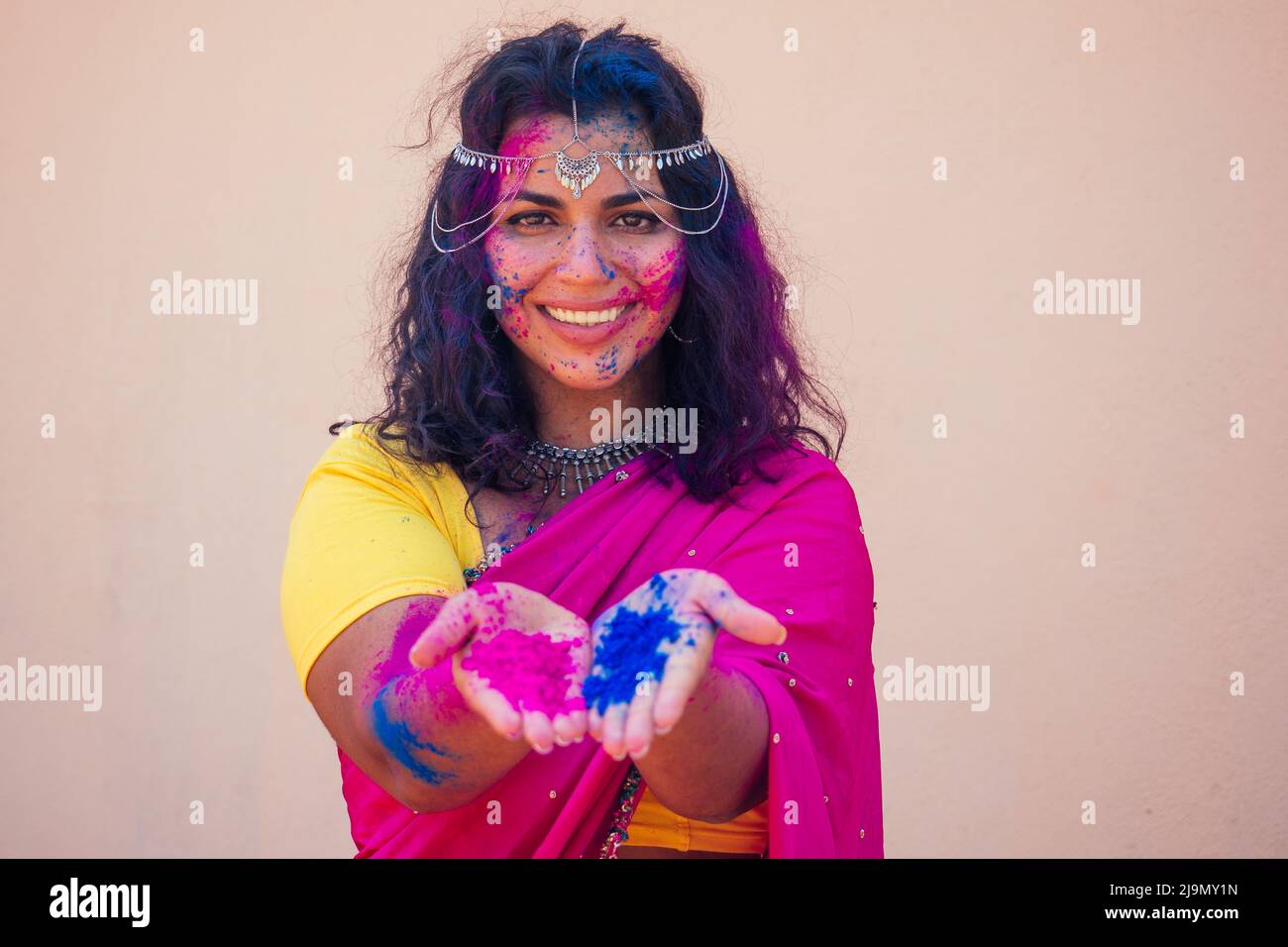 Weibliche indische Modell schneeweiß Lächeln auf holi Farbe Festival.Indian Frau in traditionellen Sari-Kleid mit schwarzen lockigen Haaren in einem rosa und blauen Farbe und Stockfoto