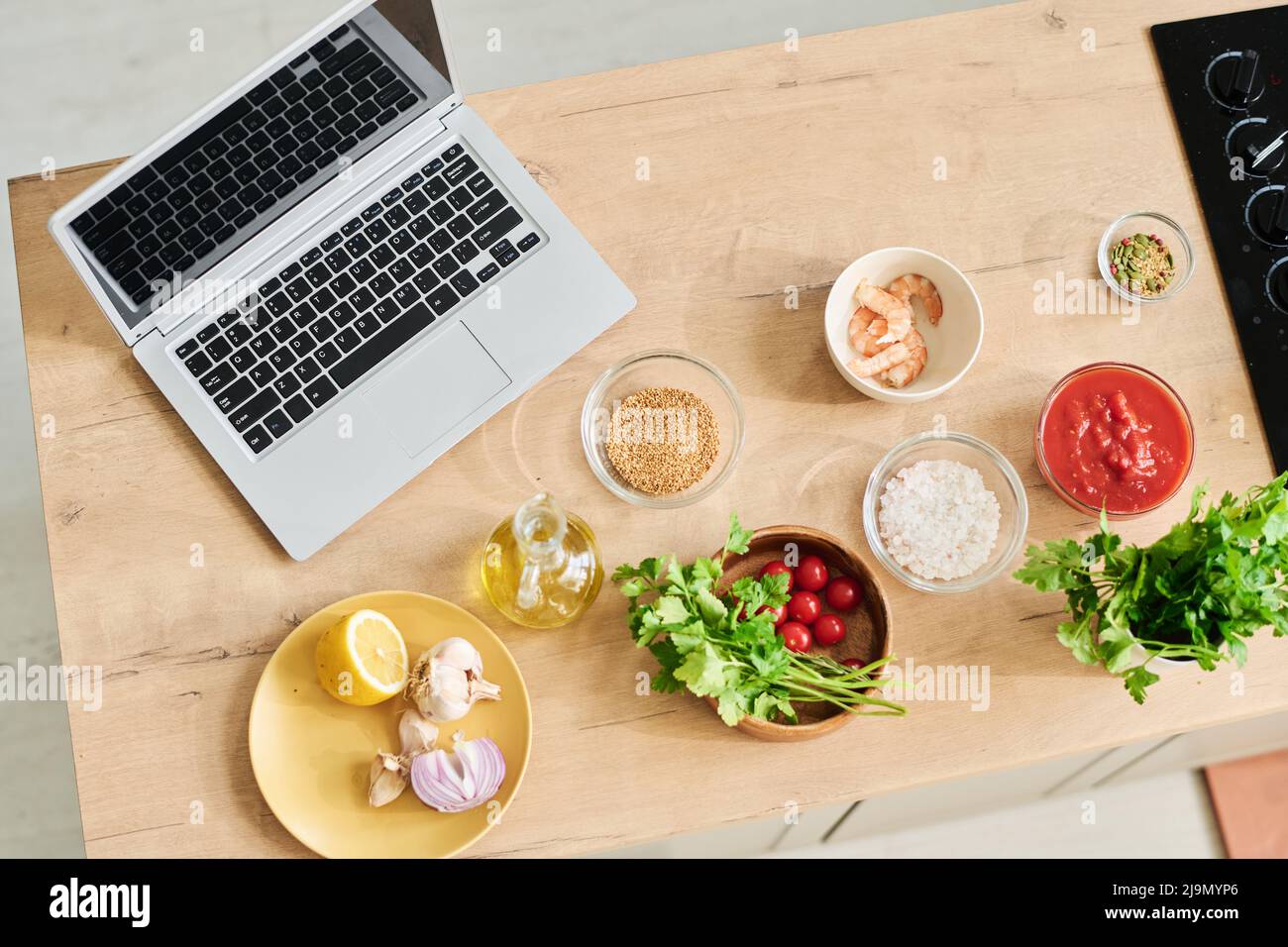 Von oben nach unten, keine Leute, flache Aufnahme von kabellosem Laptop und frischen Zutaten, die zum Kochen auf der Küchentheke zubereitet werden Stockfoto