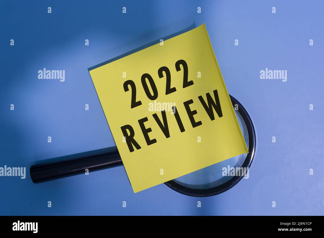 2022 Bewertung auf Klebenote mit Vergrößerungsglas vor blauem Hintergrund. Geschäftskonzept. Stockfoto