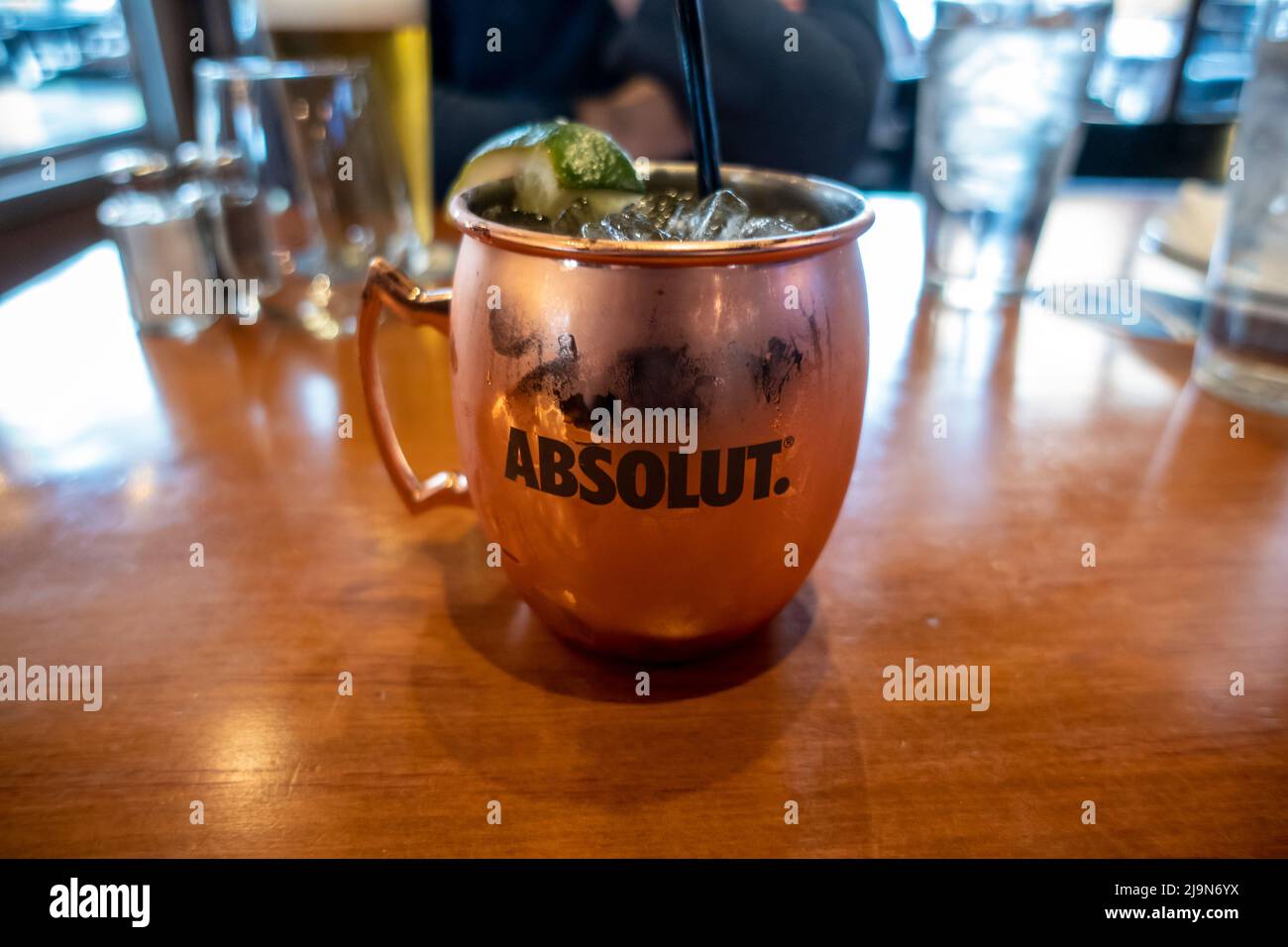 Seattle, WA USA - ca. Mai 2022: Selektiver Fokus auf ein Moscow Mule Alkoholgetränk in einem Kupferbecher auf einem Tisch in einem Restaurant. Stockfoto