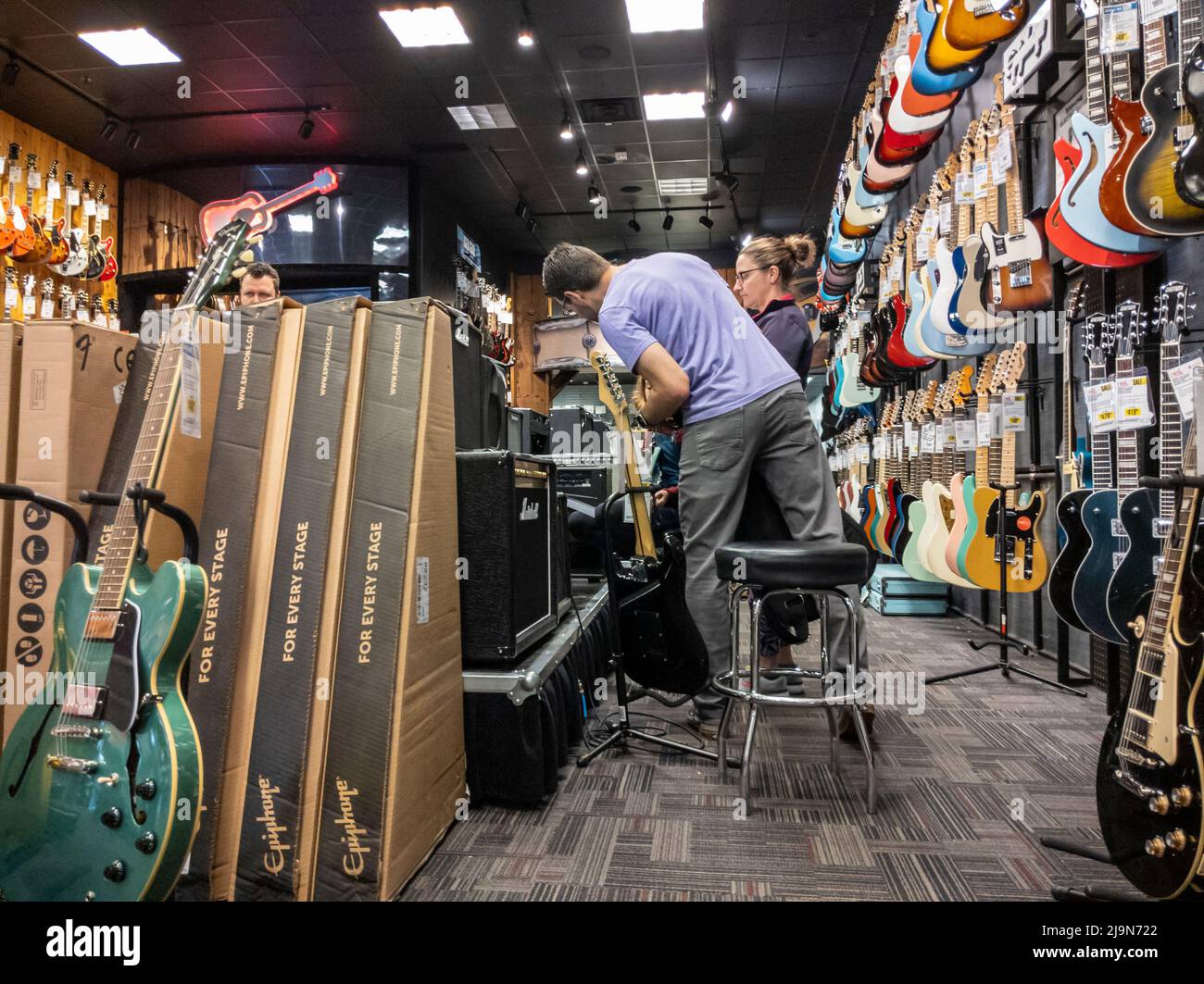 Lynnwood, WA USA - ca. Mai 2022: Leute, die in einem Guitar Center-Geschäft nach E-Gitarren und anderen Musikinstrumenten und Zubehör einkaufen Stockfoto