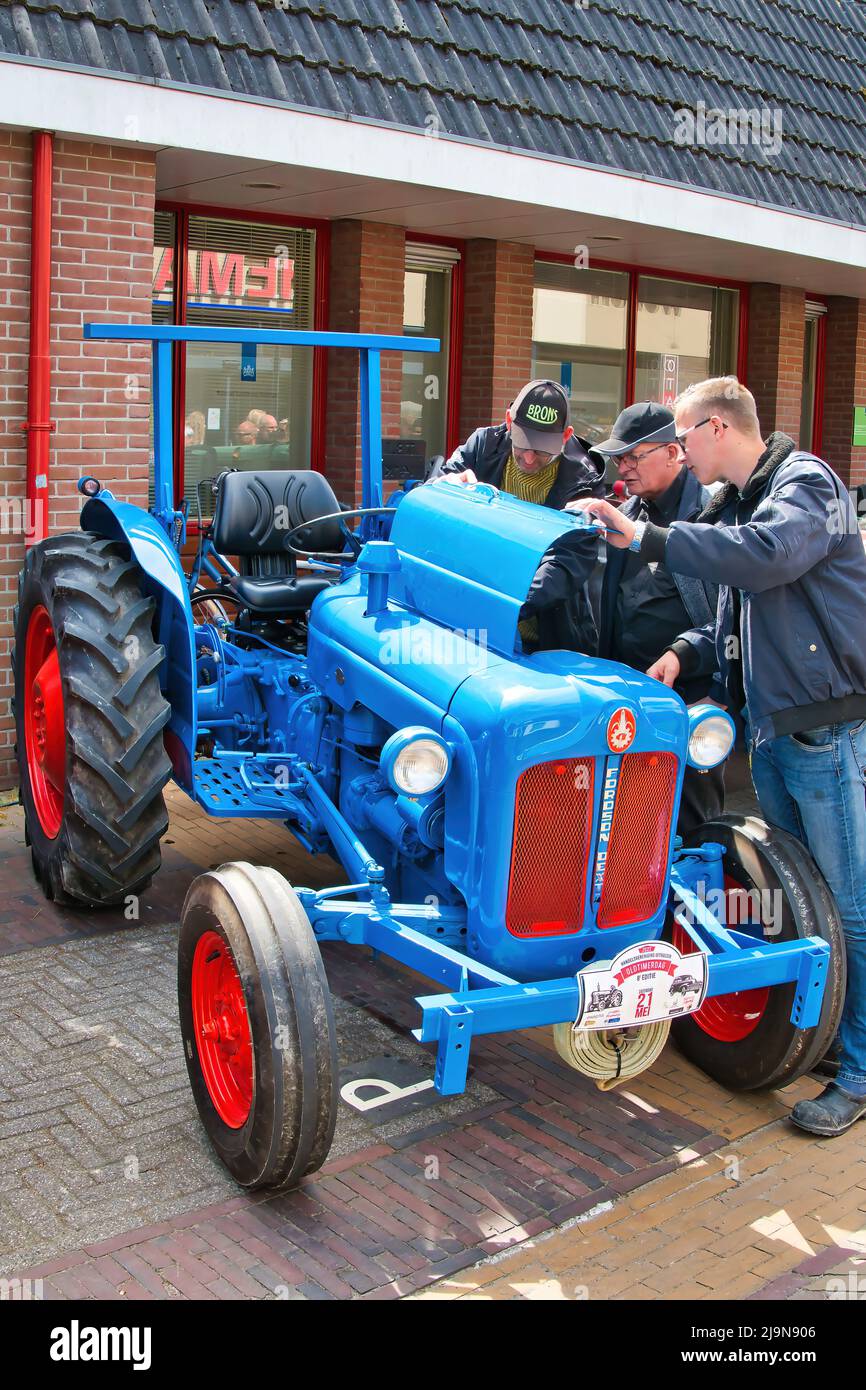 Landwirte bewundern den Motor eines Vintage Fordson Dexta Traktors auf einer Oldtimer-Ausstellung in Uithuizen, Groningen, Niederlande. Stockfoto