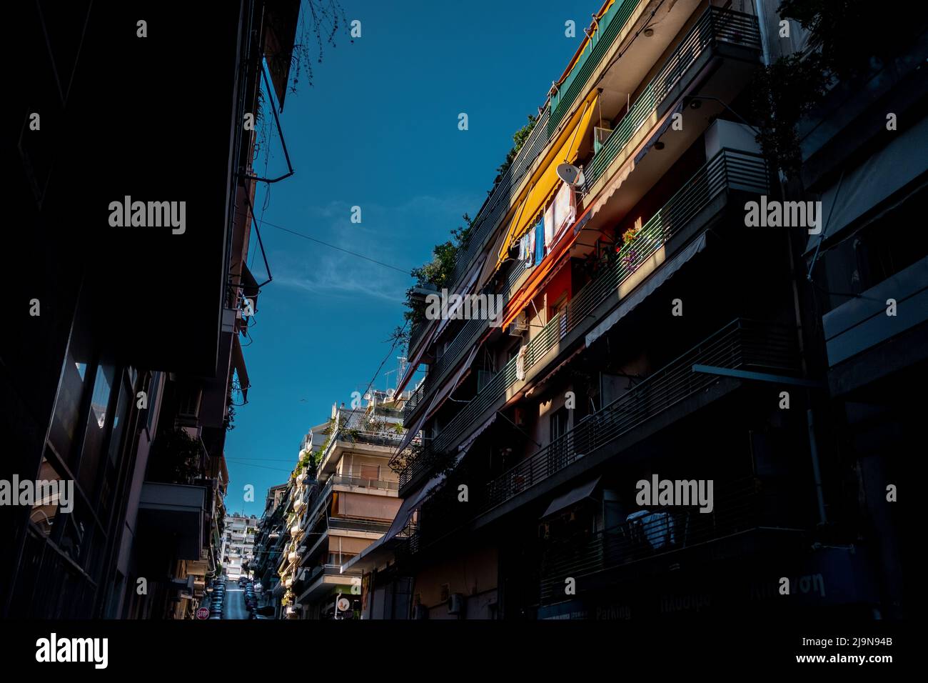 Die typische Straße Athens mit Wohnungen, die wie lange Alleen mit hoher Dichte Canyon bilden Stockfoto