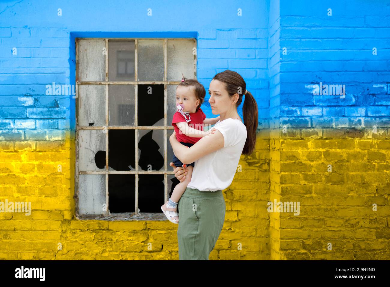Entschlossene Mutter hält ihr kleines Kind in den Armen Stockfoto