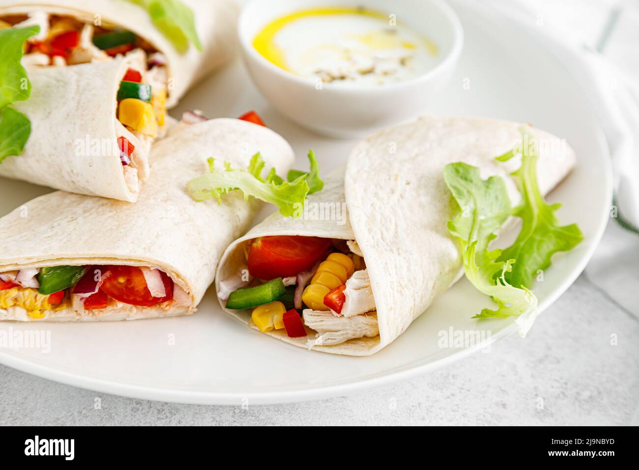 Griechisches Huhn wickelt Souvlaki mit Gemüse und Zatziki-Sause Stockfoto