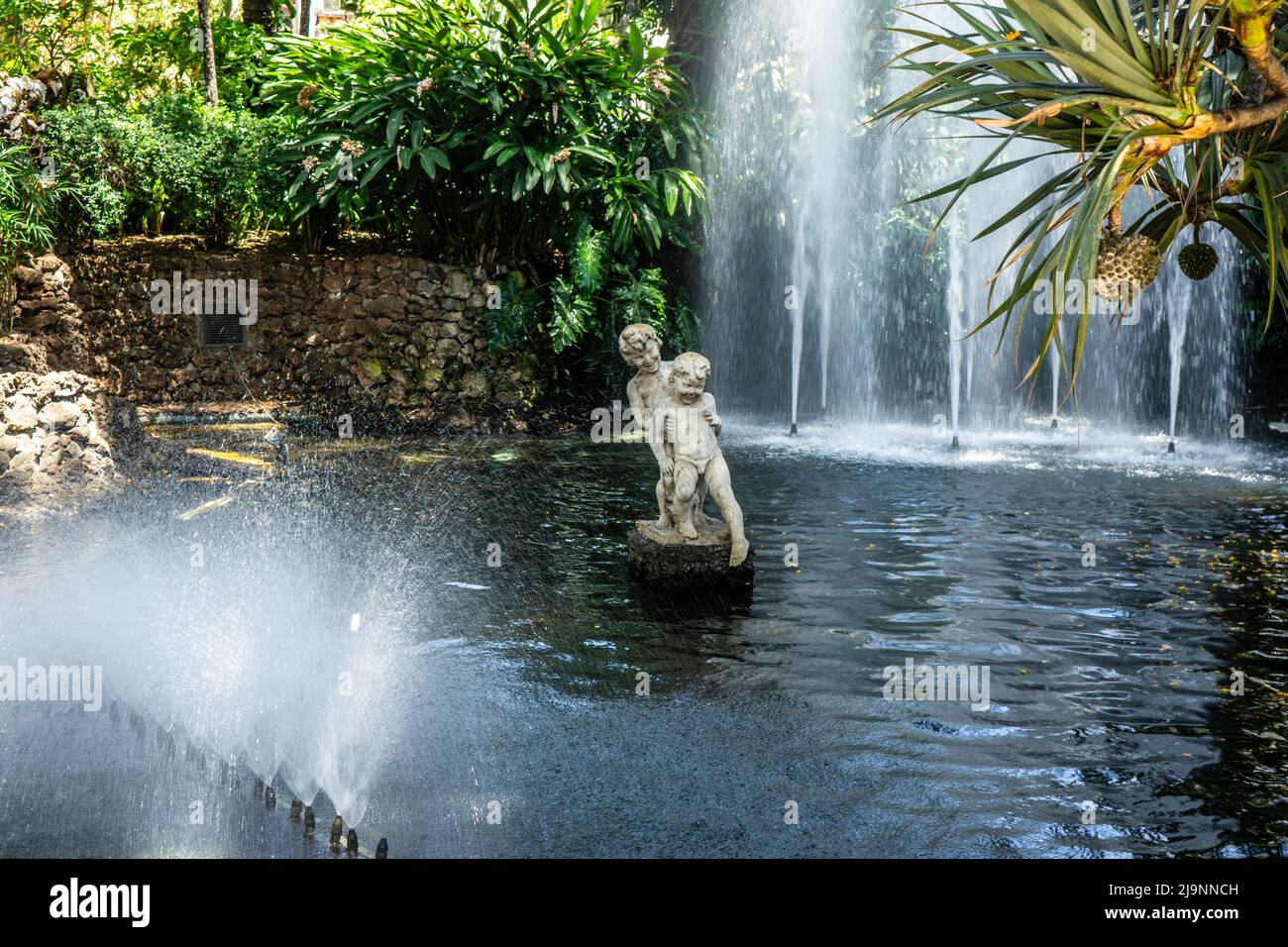 Eine Marmorstatue von zwei Jungen, die in einem Wasserfall in den Stadtgärten von Funchal, Madeira, spielen. Bildhauerin António Maria Ribeiro. Stockfoto