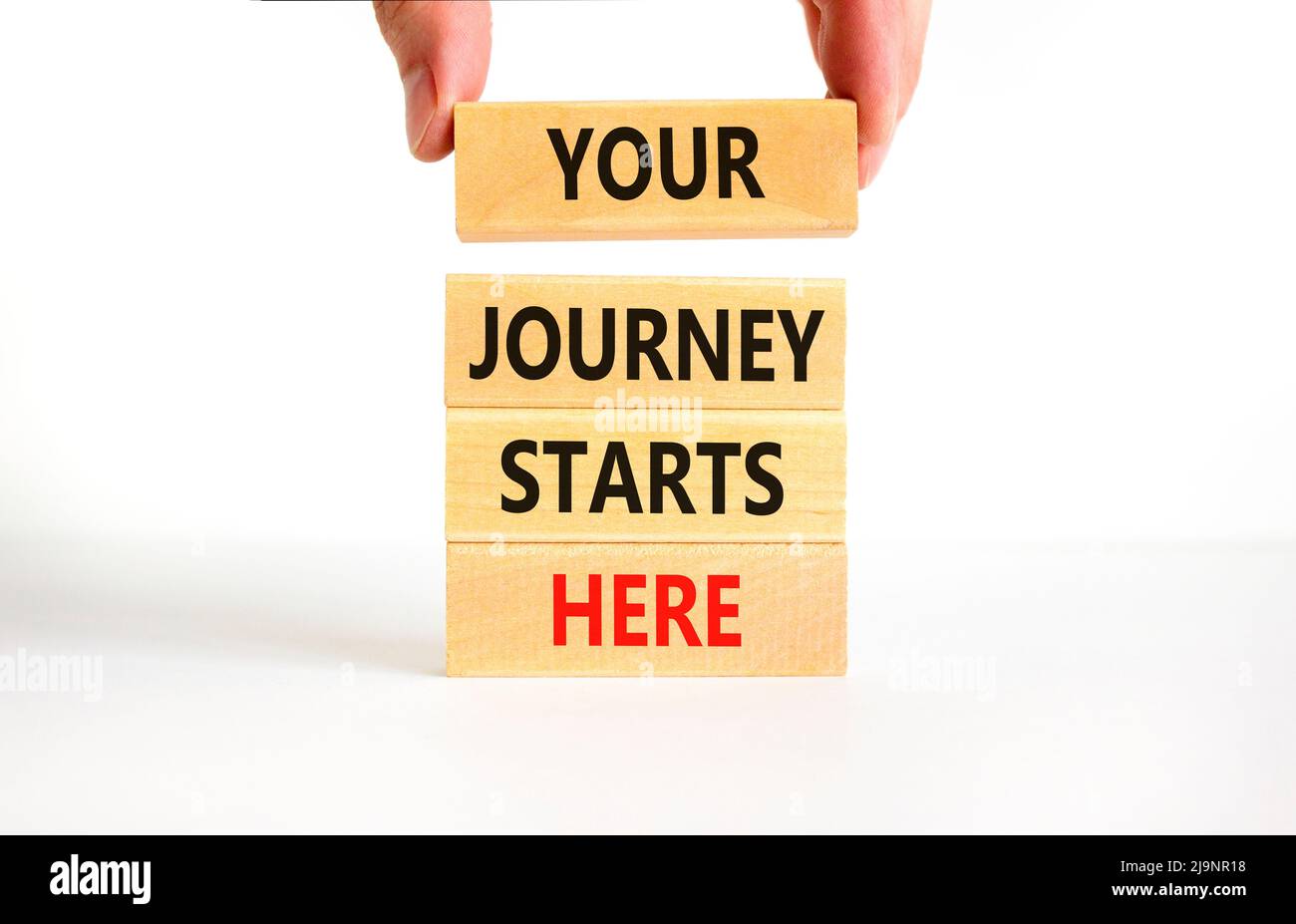 Ihre Reise beginnt hier Symbol. Konzeptworte Ihre Reise beginnt hier auf Holzblöcken auf einem schönen weißen, weißen Hintergrund. Business, motiva Stockfoto