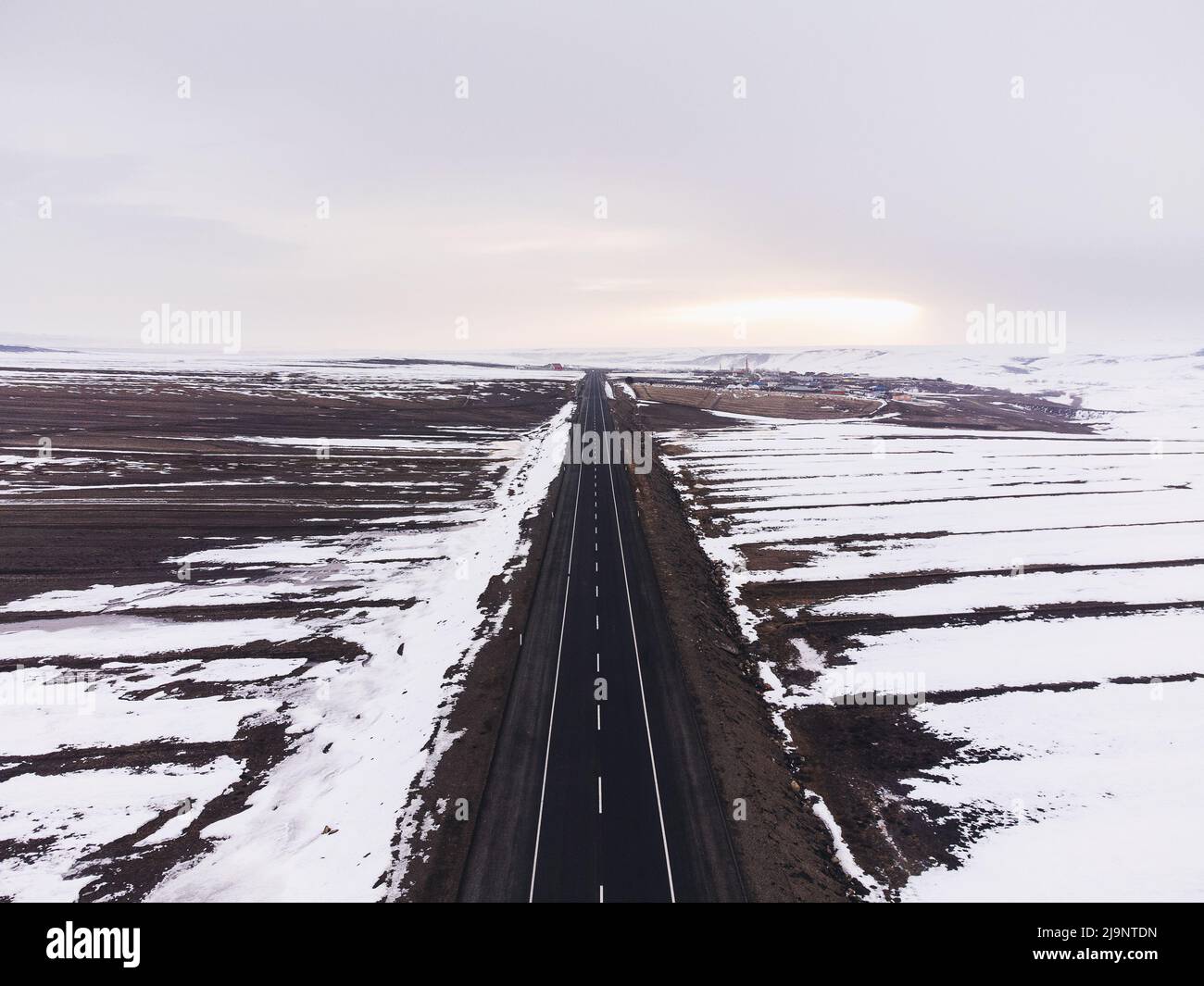 Luftaufnahme einer einspurigen Straße und Schnee im Winter. Stockfoto