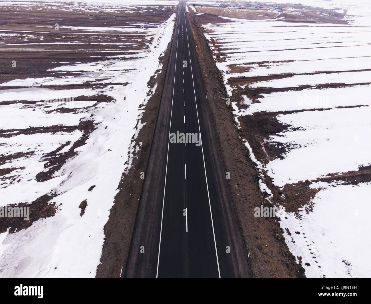 Luftaufnahme einer einspurigen Straße und Schnee im Winter. Stockfoto