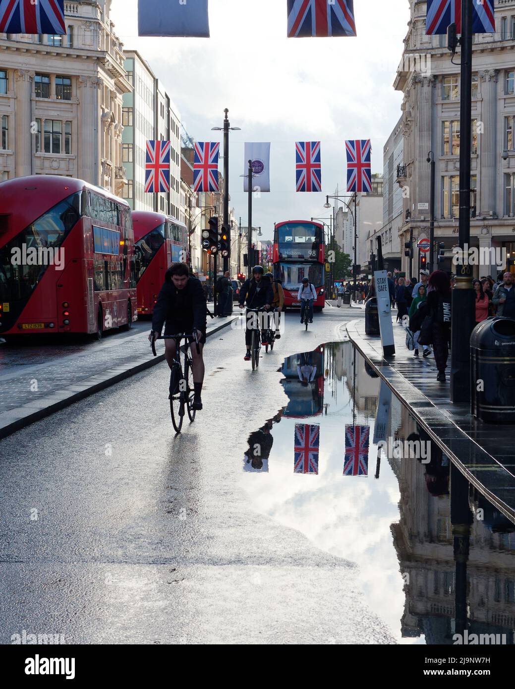London, Greater London, England, Mai 11 2022: Radfahrer und Busse auf der Oxford Street am Oxford Circus nach starkem Regen haben Überschwemmungen auf der Straße. Stockfoto