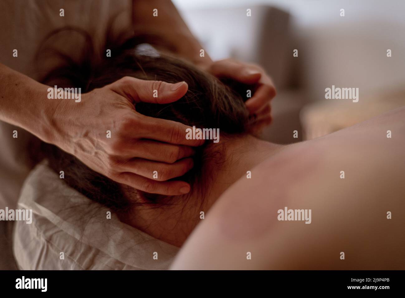 Nahaufnahme der Hände eines Masseurs, der eine junge Frau massiert, traditionelle chinesische Medizin. Stockfoto