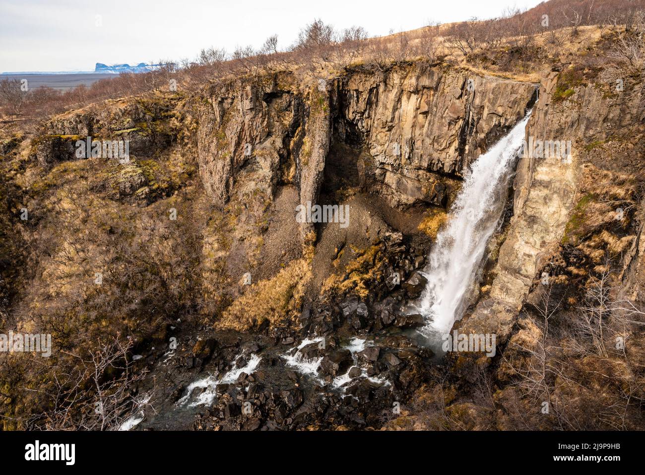Malerische Spätwinterlandschaft am Wasserfall Hundafoss, wo der Fluss Stórilækur im isländischen Skaftafell-Naturschutzgebiet in eine Schlucht stürzt Stockfoto