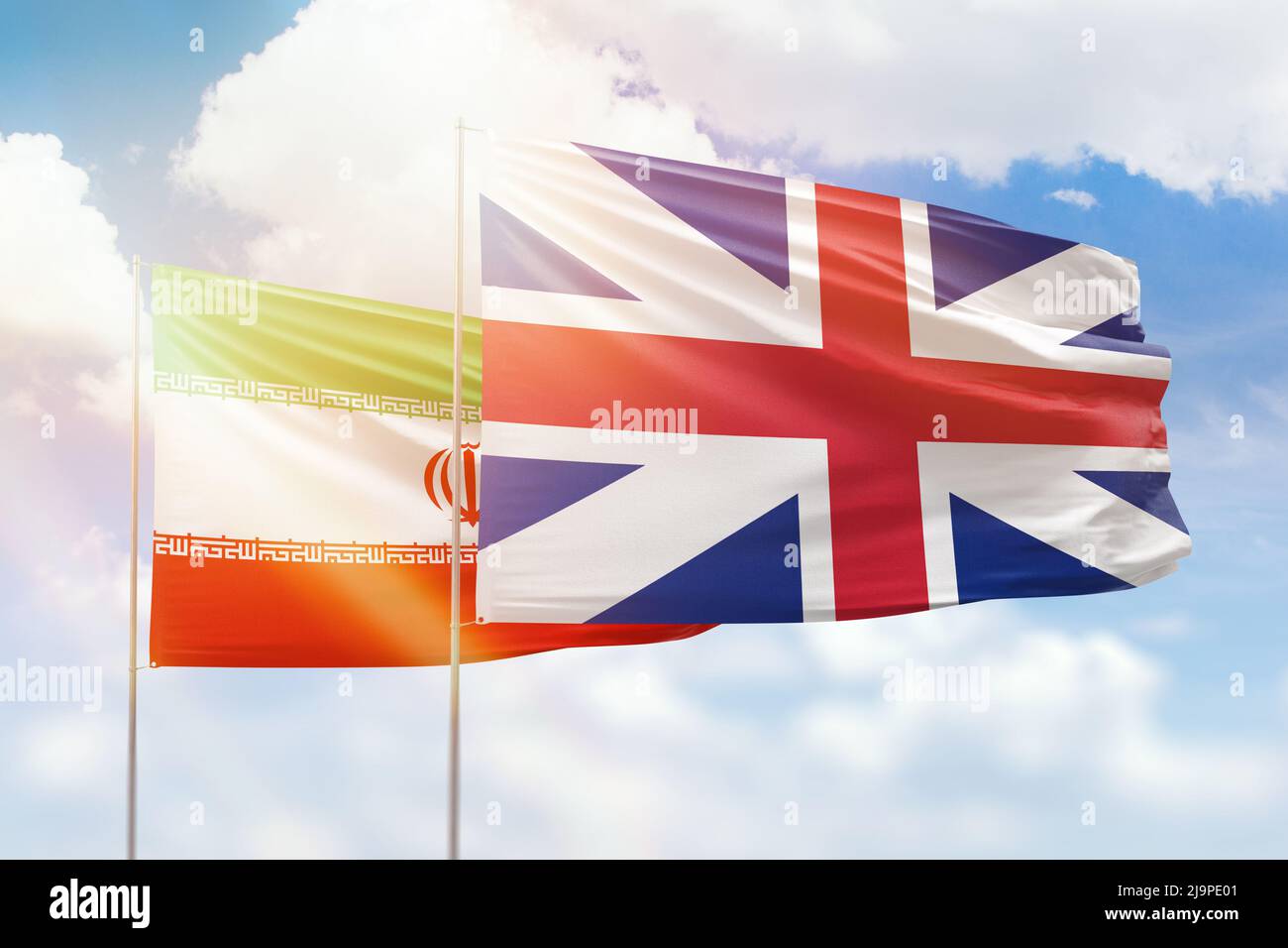 Sonniger blauer Himmel und Flaggen von Großbritannien und dem iran Stockfoto