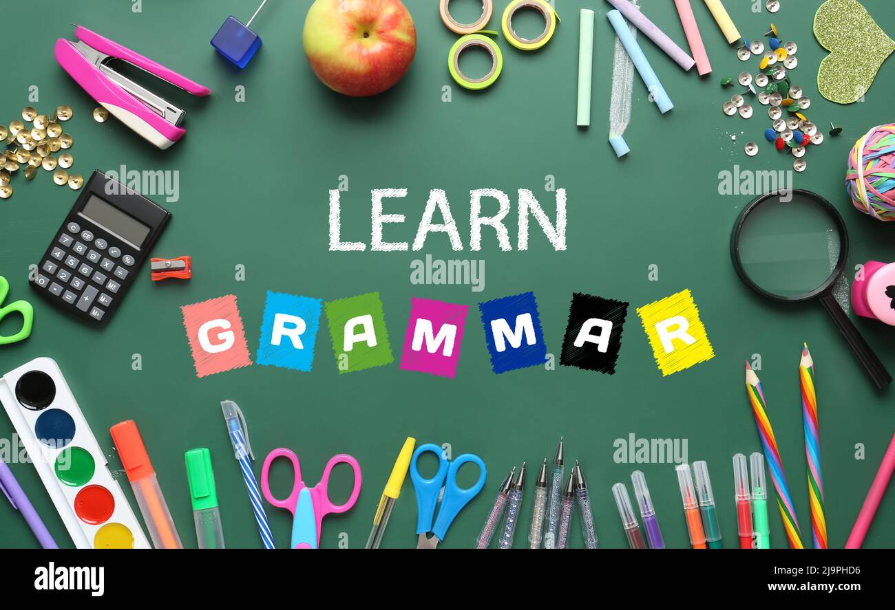 Text GRAMMATIK lernen und verschiedene Schreibwaren auf der Schulschultafel Stockfoto