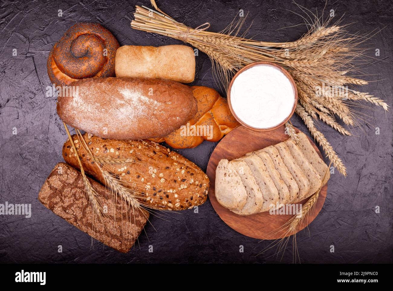 Weißbrot und Roggenbrot, Brötchen und Creme aus der Nähe. Zusammensetzung mit Broten. Stockfoto