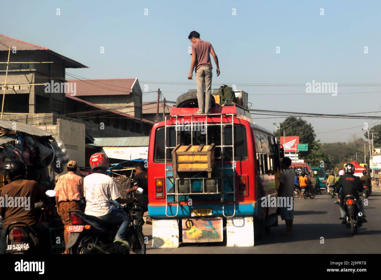Ein Minibus, der auf einer befahrenen Straße in Waingapu, East Sumba, East Nusa Tenggara, Indonesien, auf Passagiere und Fracht wartet. Stockfoto
