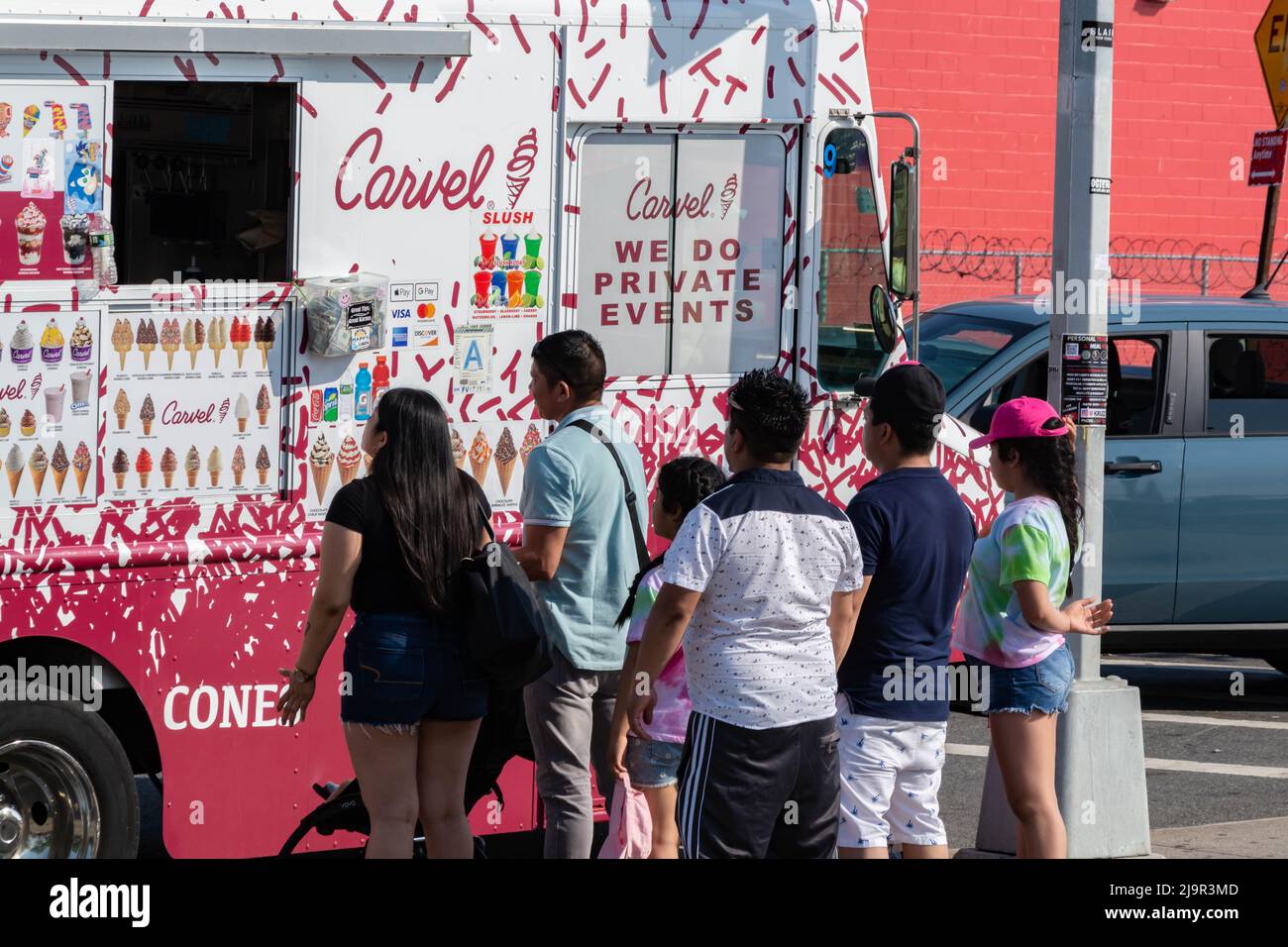 Eine Schlange von Leuten, die an einem heißen Sommertag in Brooklyn, NY, am Eiswagen warten Stockfoto