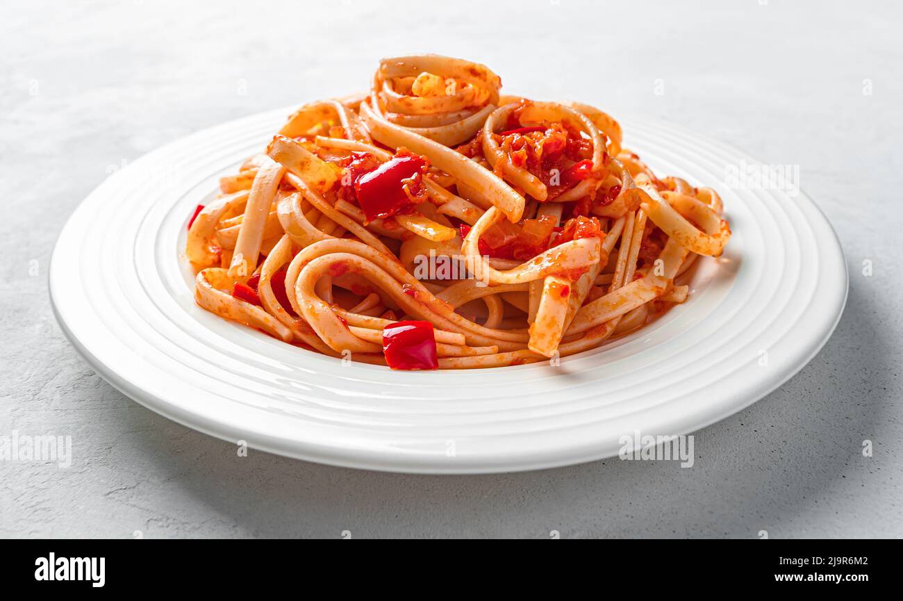 Pasta mit traditioneller Tomatensauce auf grauem Hintergrund. Pasta mit Gemüsesauce. Stockfoto