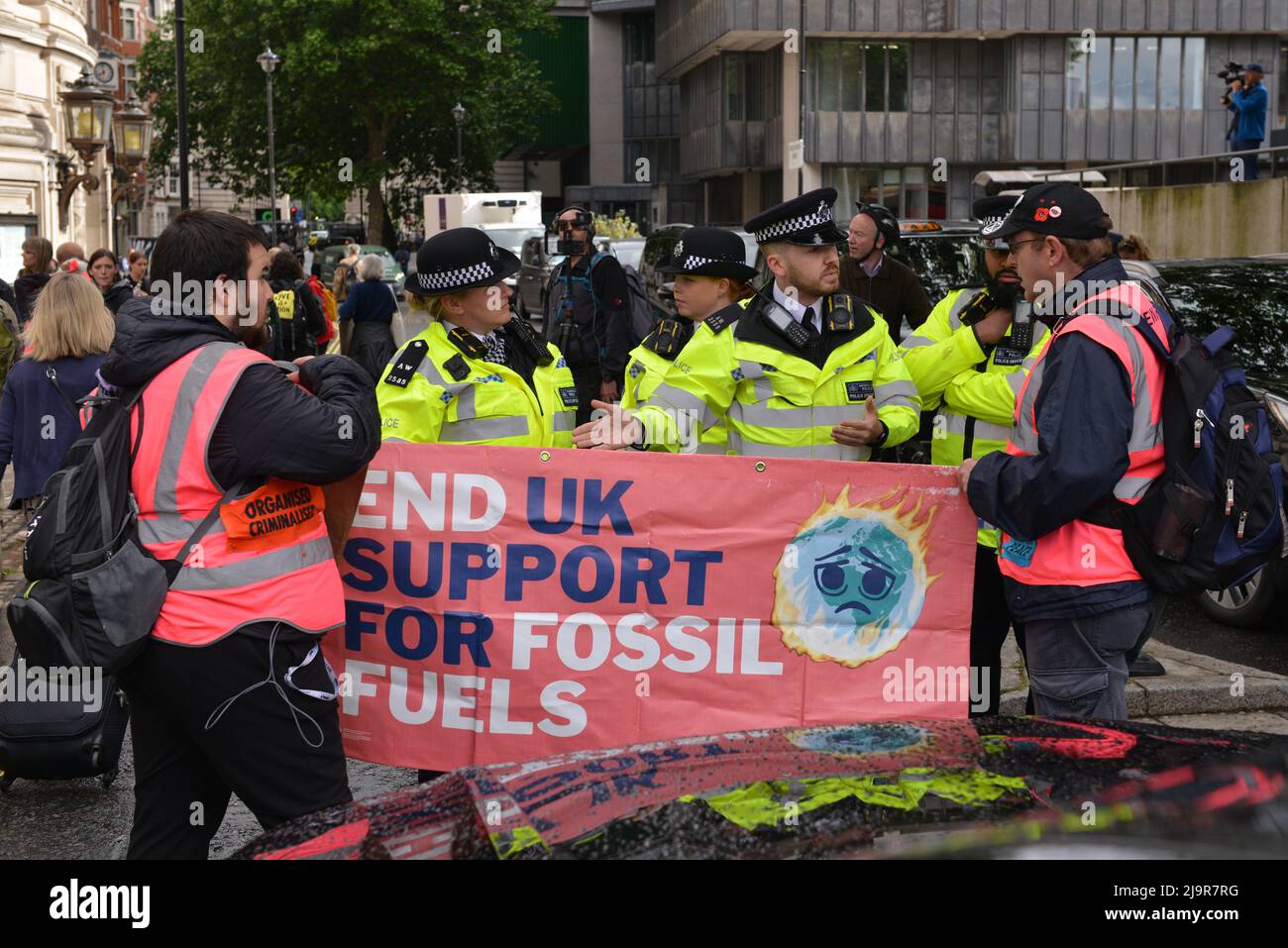 Polizeibeamte halten Demonstranten davon ab, die Straße zu blockieren. Protestierende der Extinction Rebellion versammelten sich in der methodistischen Central Hall Westminster in London, um die Shell-Jahreshauptversammlung zu stoppen. Stockfoto