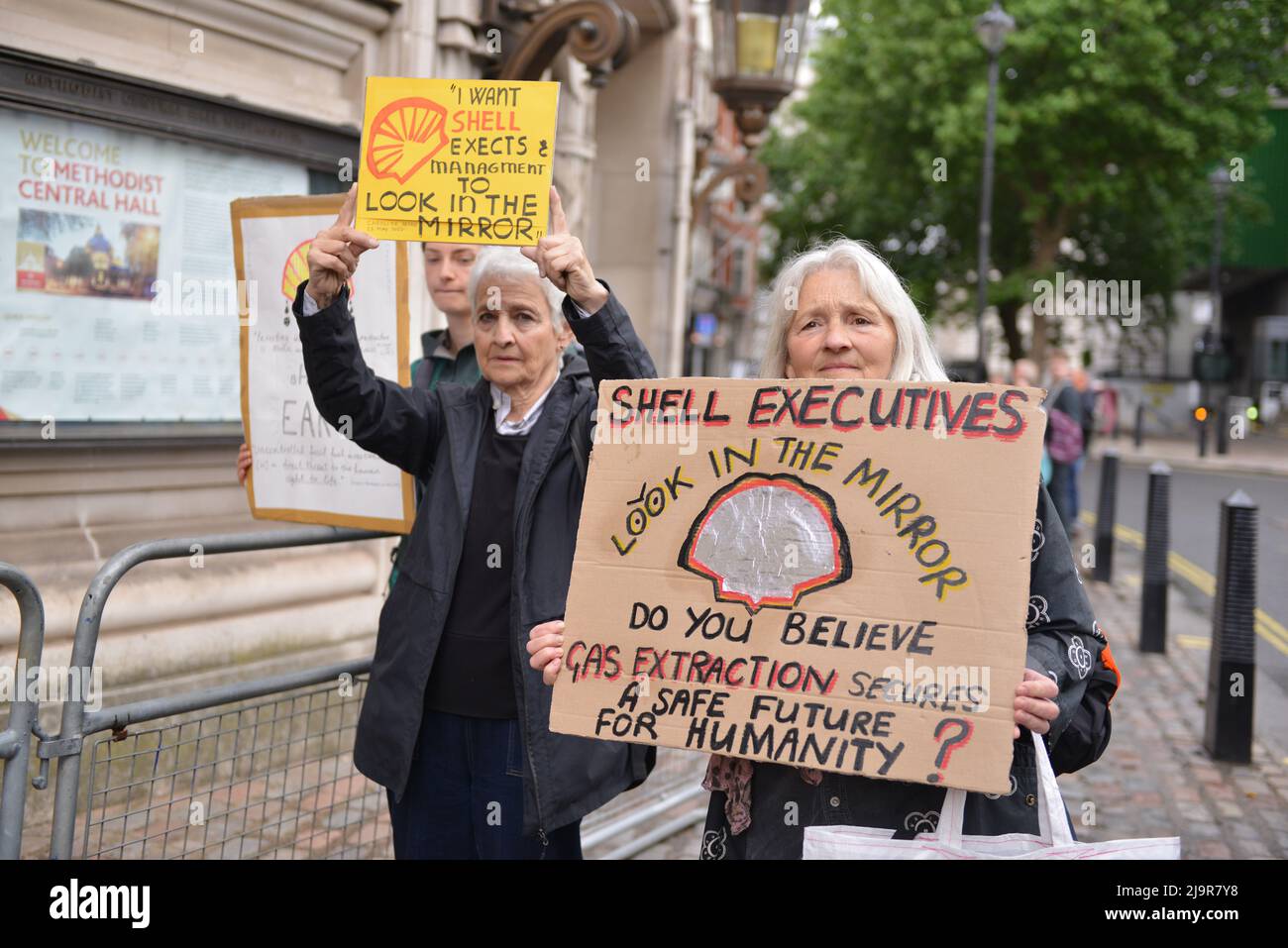 Demonstranten halten Plakate an der Demonstration. Protestierende der Extinction Rebellion versammelten sich in der methodistischen Central Hall Westminster in London, um die Shell-Jahreshauptversammlung zu stoppen. Stockfoto