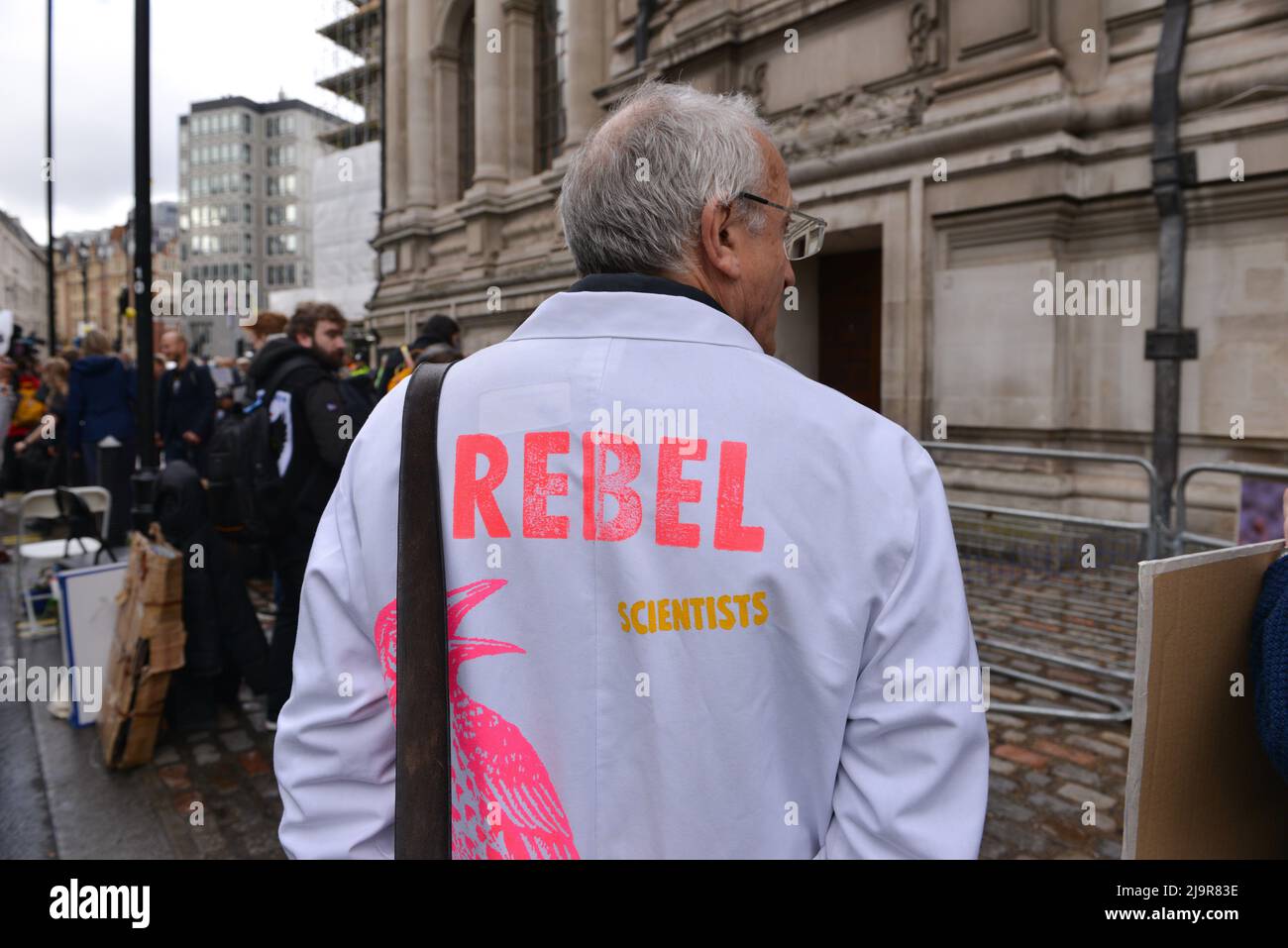 Der Proester trägt einen Labormantel mit dem Slogan Rebel Scientists. Protestierende der Extinction Rebellion versammelten sich in der methodistischen Central Hall Westminster in London, um die Shell-Jahreshauptversammlung zu stoppen. Stockfoto