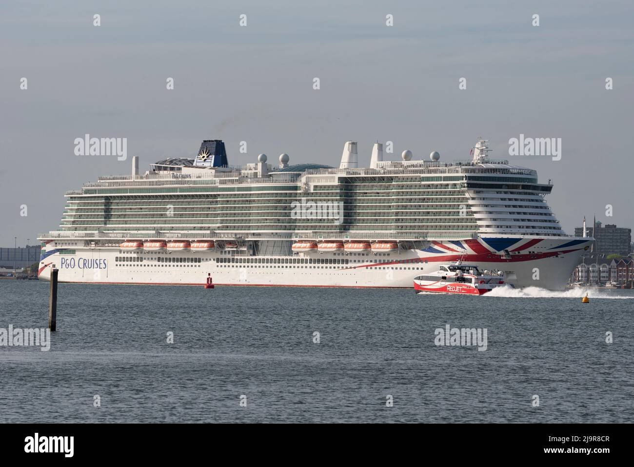 Southampton, England, Großbritannien. 2022. Der Kreuzfahrtdampfer Iona fährt ab dem Hafen von Southampton, Großbritannien. Eine Redjet-Fähre passiert ihren Bogen. Stockfoto
