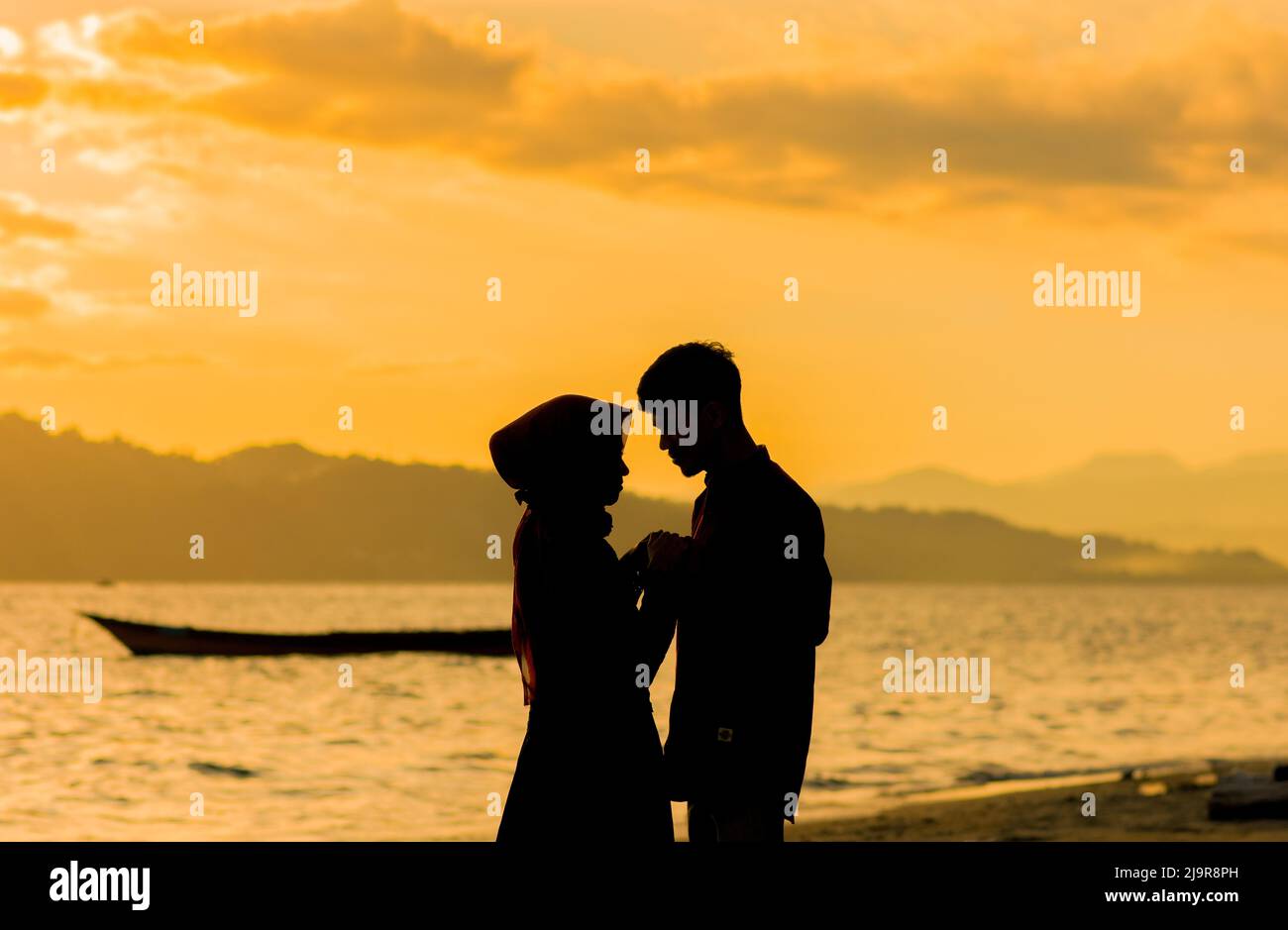 Silhouette Romantik moeslim Paar in Sonnenuntergang am Strand Stockfoto