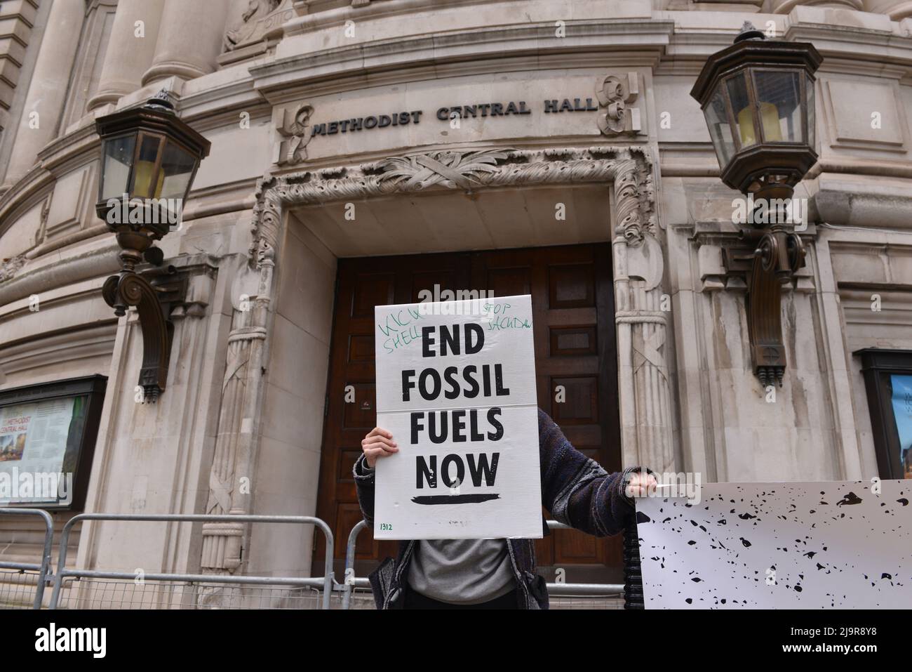 Protestler hält Plakat bei der Demonstration. Protestierende der Extinction Rebellion versammelten sich in der methodistischen Central Hall Westminster in London, um die Shell-Jahreshauptversammlung zu stoppen. Stockfoto