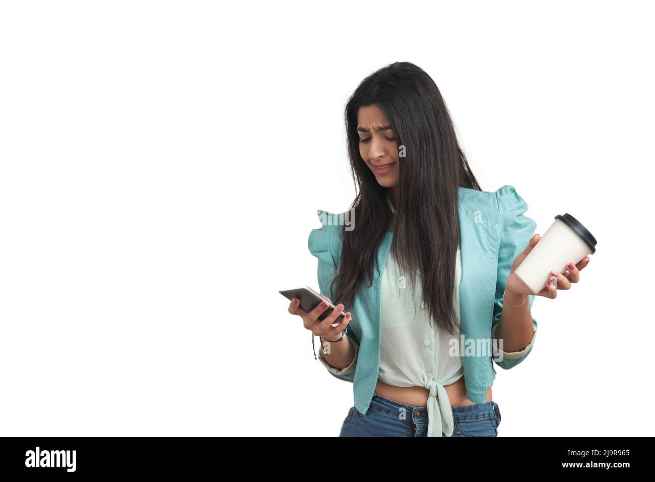Junge venezolanische Frau, die das Smartphone benutzt und zuckend, isoliert. Stockfoto