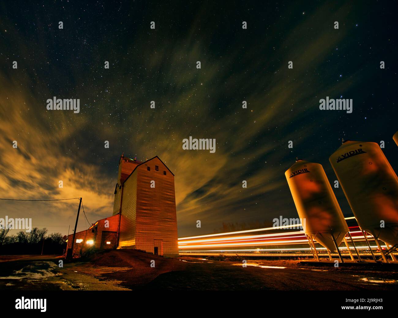 Kanada, Manitoba. Nachts Streifen Körnerelevator- und Bahnlichter. Stockfoto
