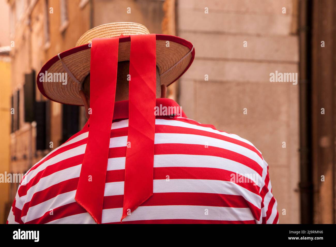 Italien, Venedig. Gondelfahrer mit rot-weiß gestreiftem Hemd und Hut mit rotem Band. Stockfoto