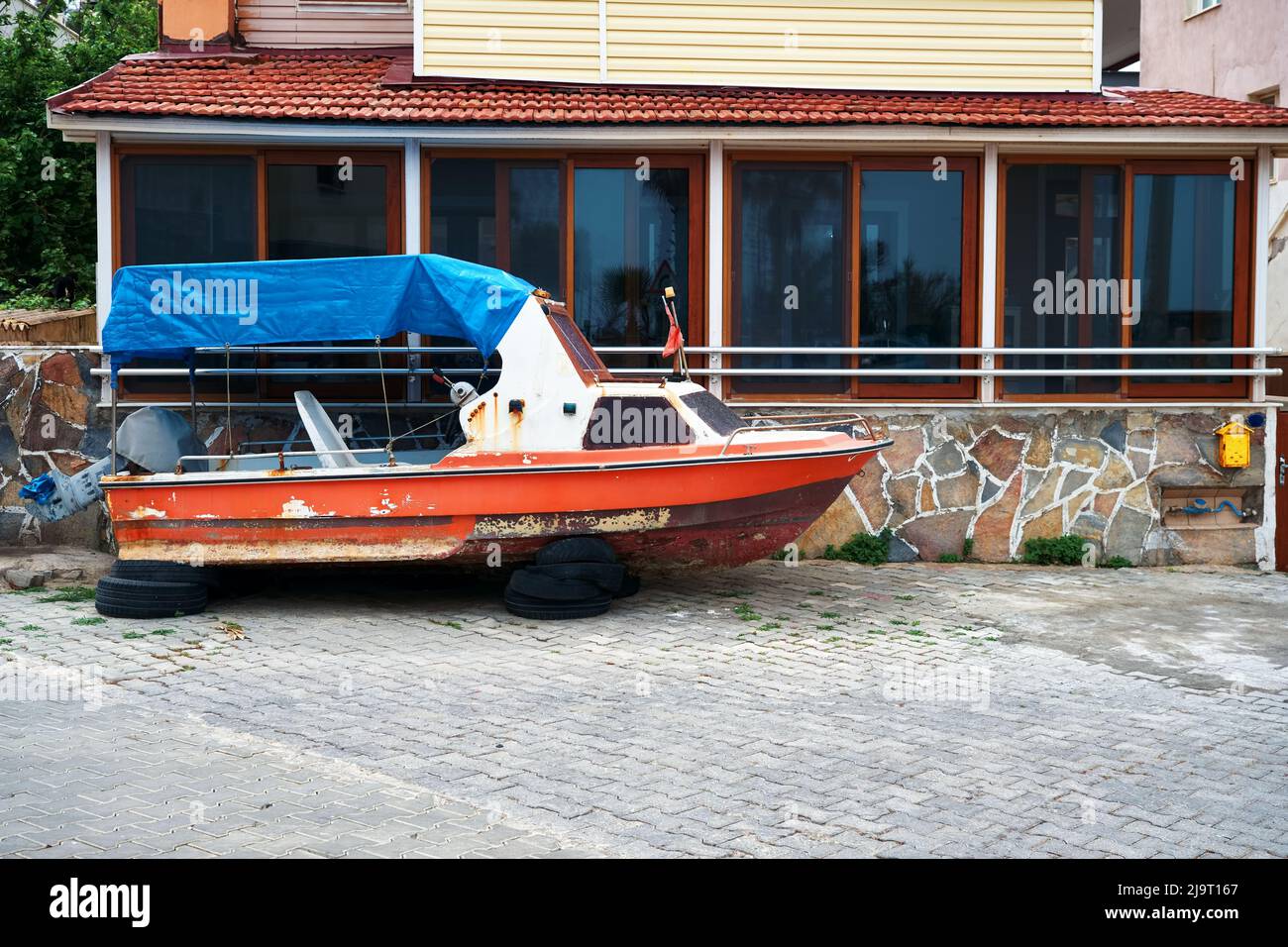 Verlassene Holzboot an Land vor einem Haus. Stockfoto