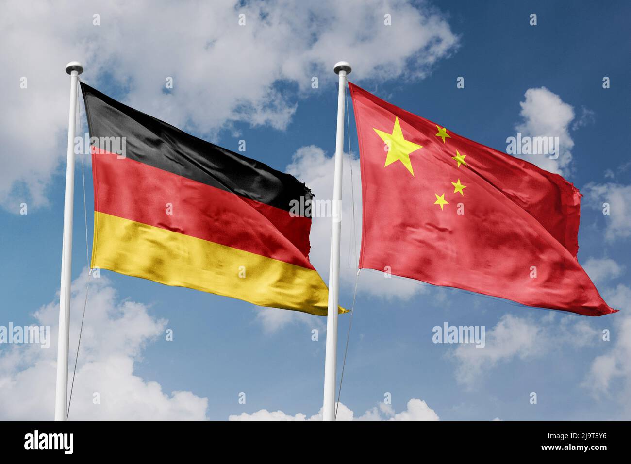 Deutschland und China zwei Flaggen auf Fahnenmasten und blau bewölktem Himmel Hintergrund Stockfoto