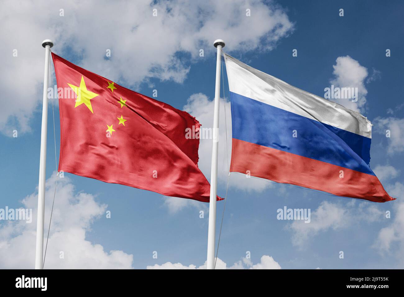 China und Russland zwei Flaggen auf Fahnenmasten und blau bewölktem Himmel Hintergrund Stockfoto