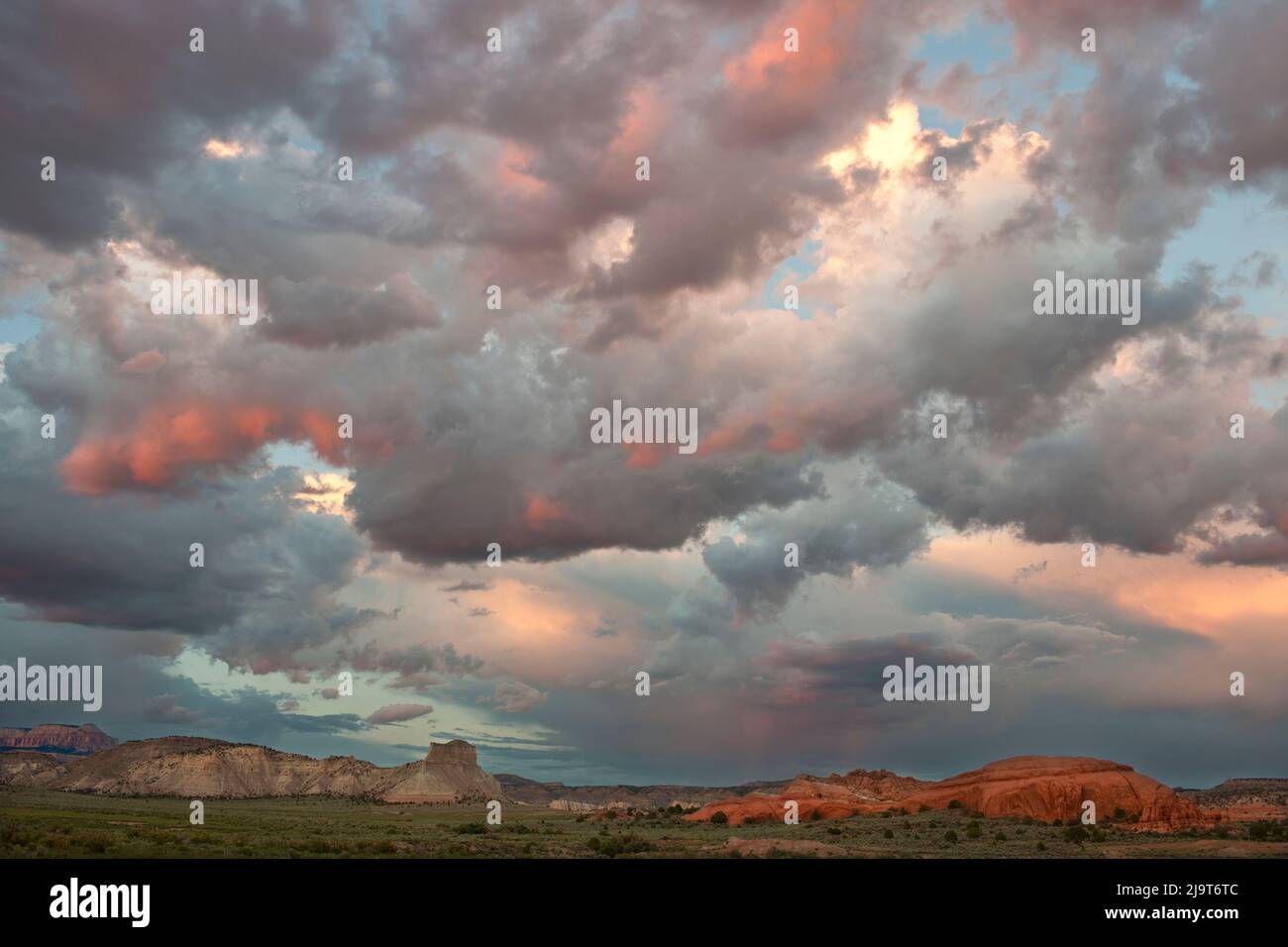 USA, Utah. Landschaft mit Sandsteinformationen und aufleuchtenden Sturmwolken bei Sonnenuntergang. Stockfoto