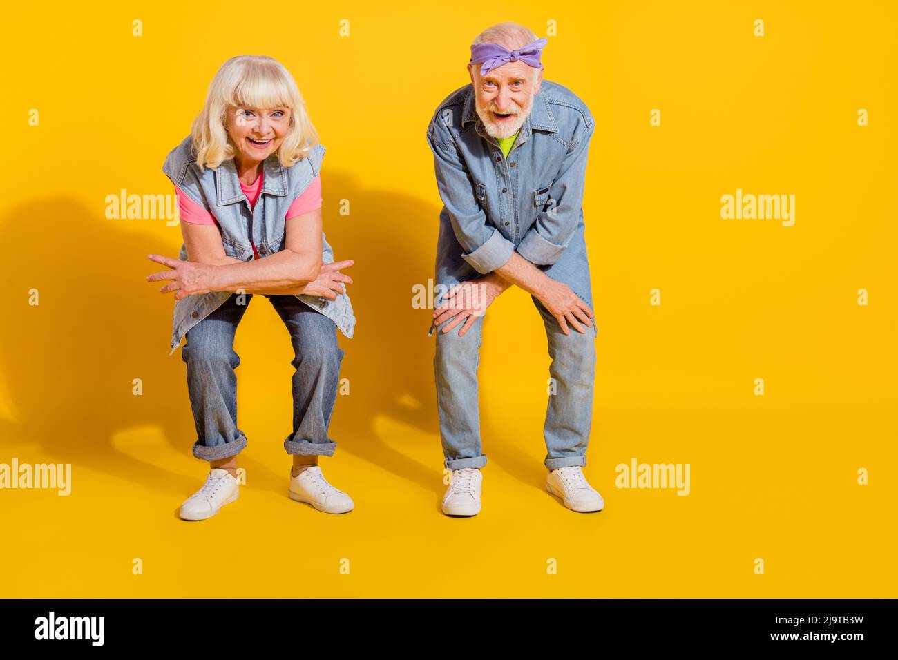 Foto von niedlichen süßen Mann Frau tragen Jeans Hemden tanzen leeren Raum isoliert gelbe Farbe Hintergrund Stockfoto